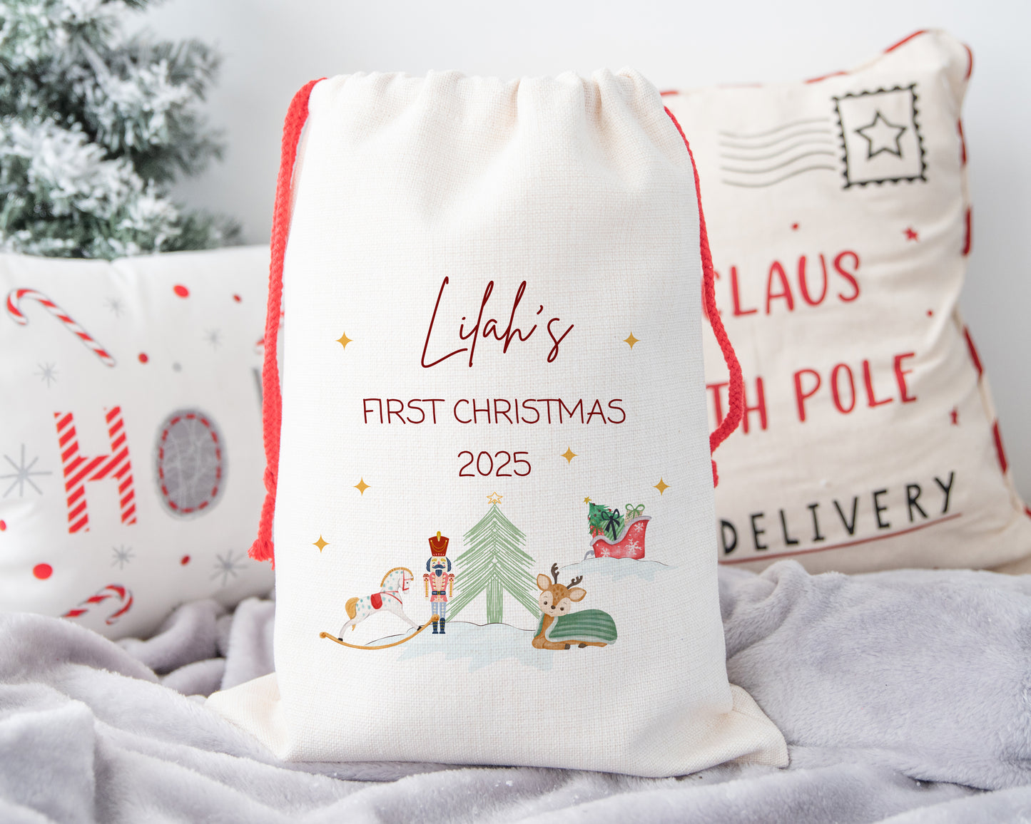 Personalized Christmas gift bag with festive design and text on a soft surface.