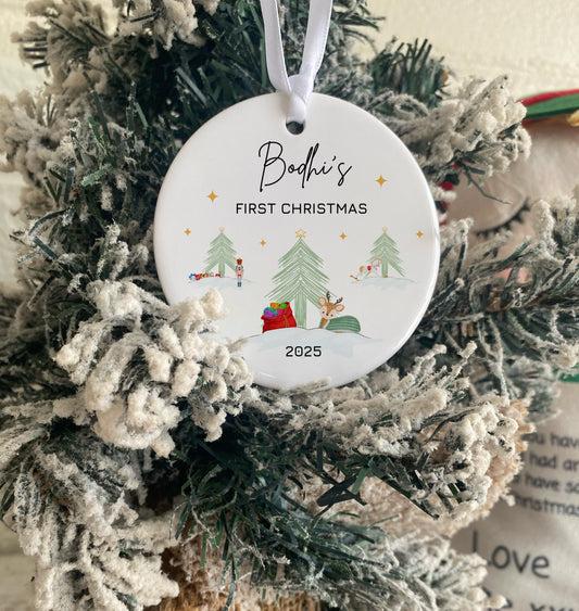 Christmas ornament with 'Bodhi's First Christmas 2025' text on a decorated tree.