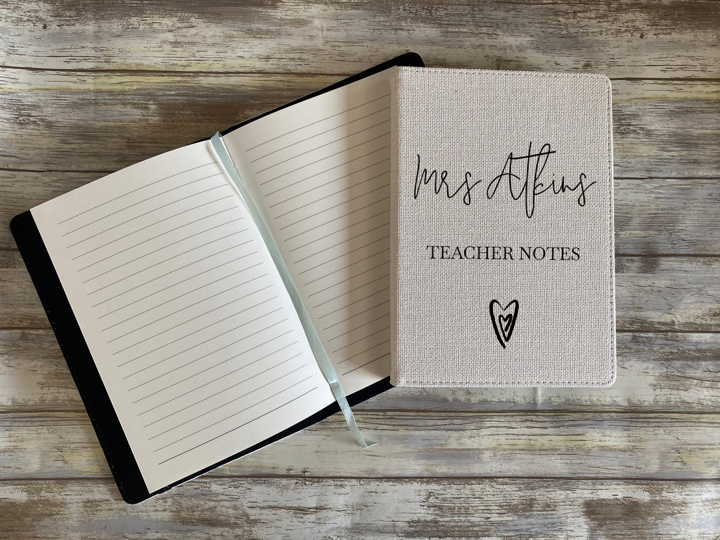 Open notebook with 'Mrs. Atkins Teacher Notes' on a wooden surface