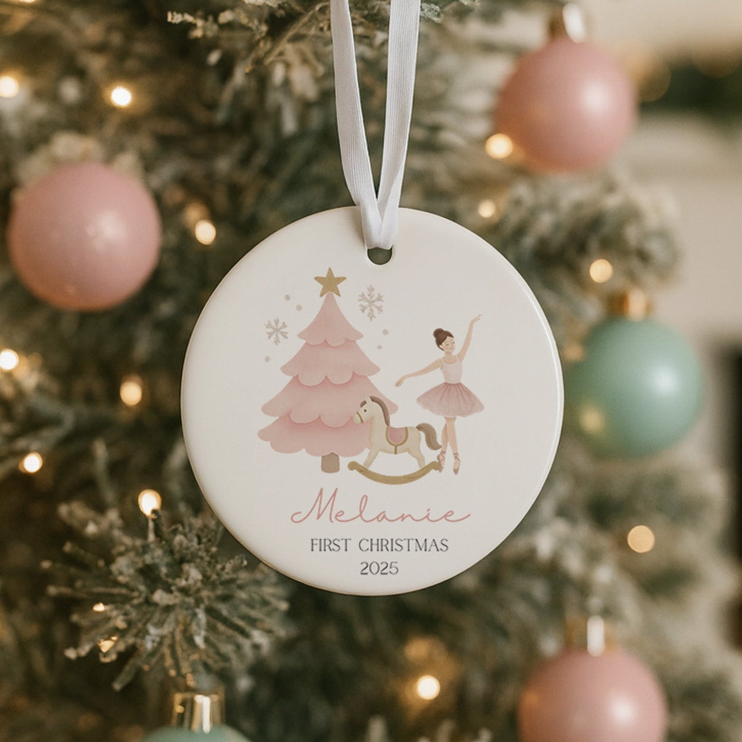 Decorative Christmas ornament with a child and tree design hanging on a tree.