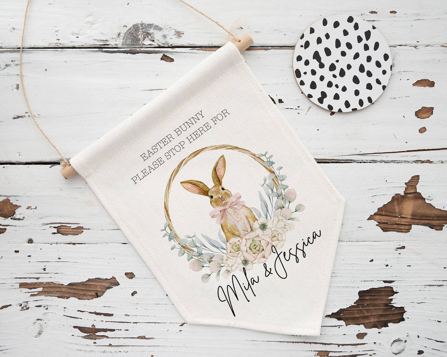 Personalised Easter bunny stop here sign featuring a cute bunny illustration with floral wreath and pastel accents. Customised with children’s names "Mila & Jessica", this hanging fabric flag is perfect Easter decor for kids, ideal for gifting or holiday tradition keepsake.