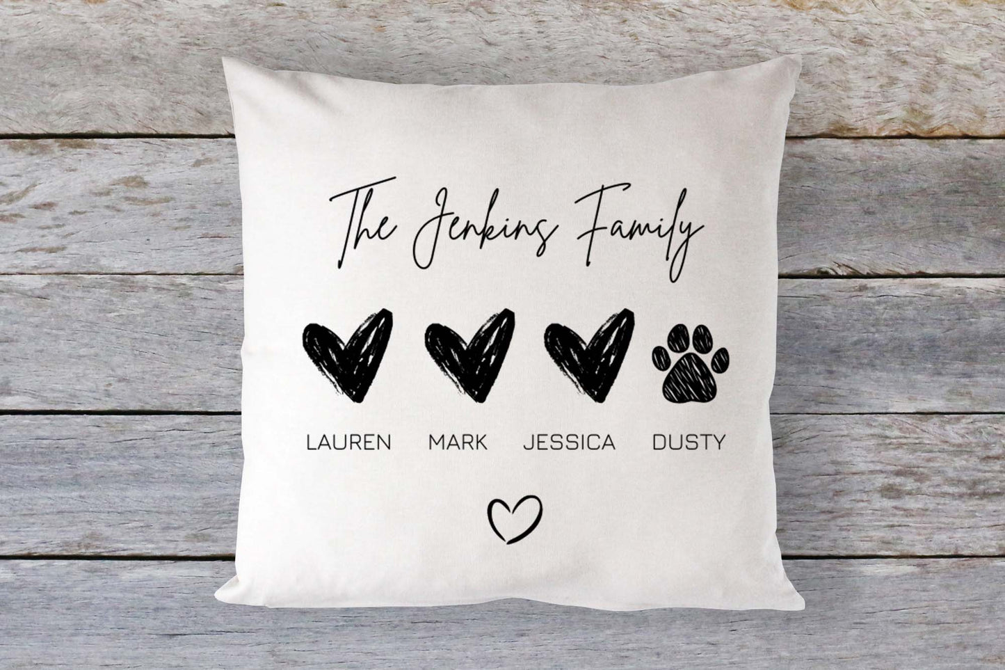Personalised family cushion with three black hearts and a paw print, custom printed with family member names including a pet, on a neutral background.