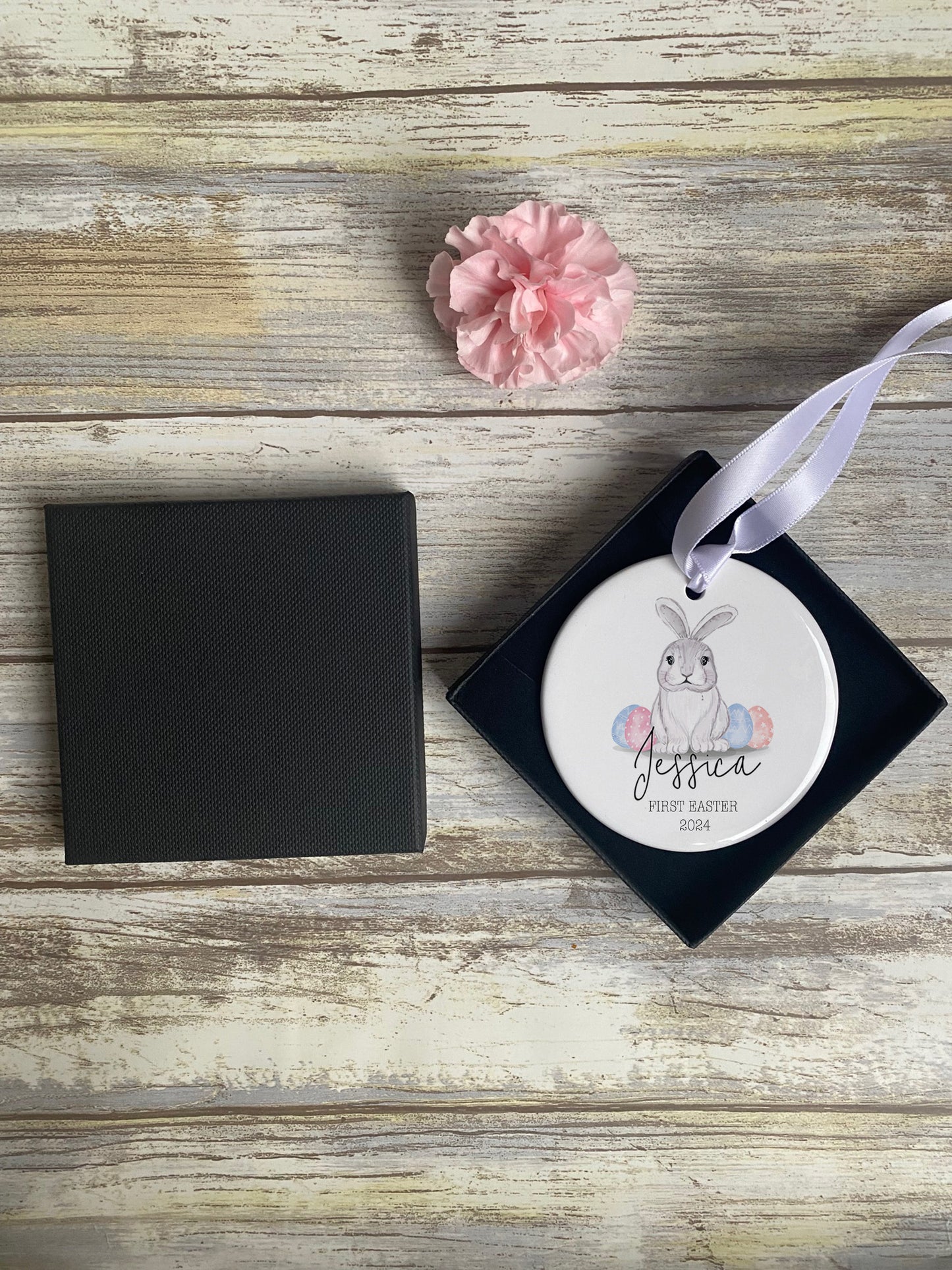 Unique personalised baby’s first Easter gift – ceramic hanging decoration featuring a cute bunny with pastel eggs, custom name "Jessica", and "First Easter 2024" text, displayed in a luxury gift box with ribbon.