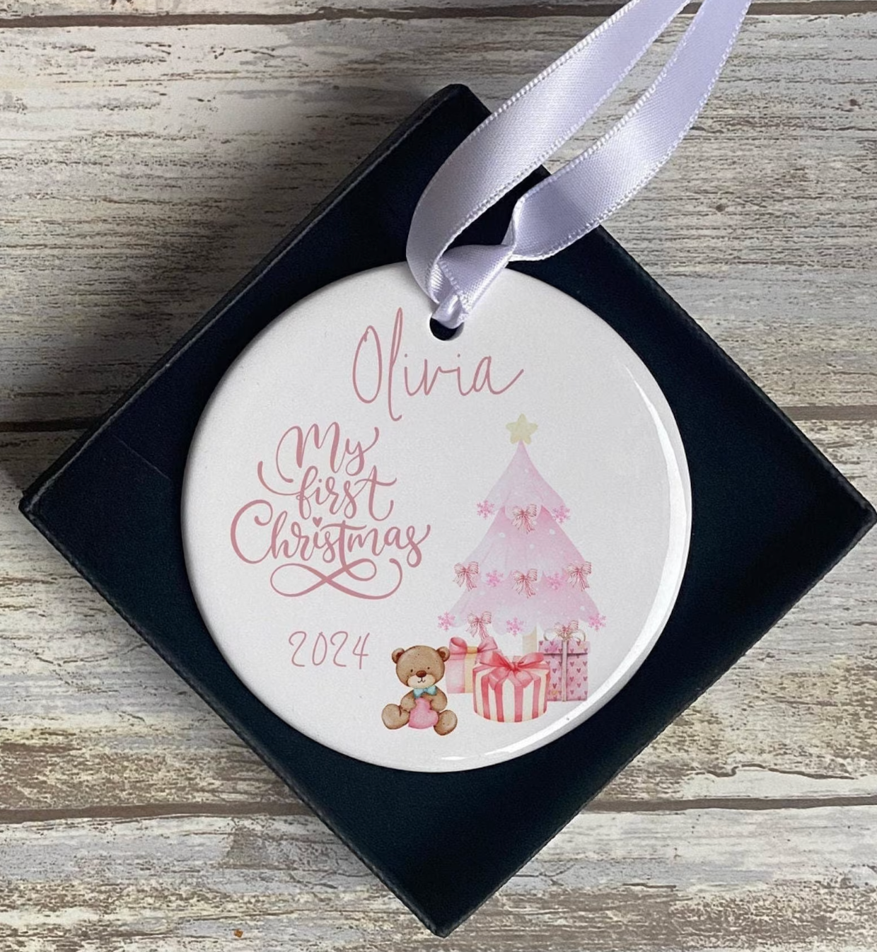 Personalised baby's first Christmas ornament with pink tree, teddy bear, gifts, and name and year 2025 printed on ceramic decoration