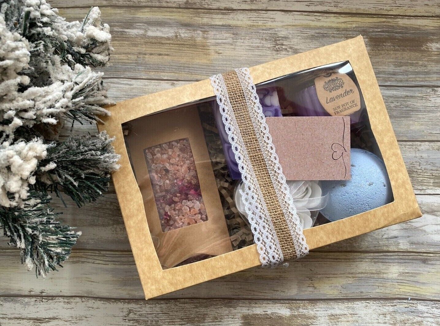 Gift set with bath bombs and soap in a decorative box on a wooden surface.