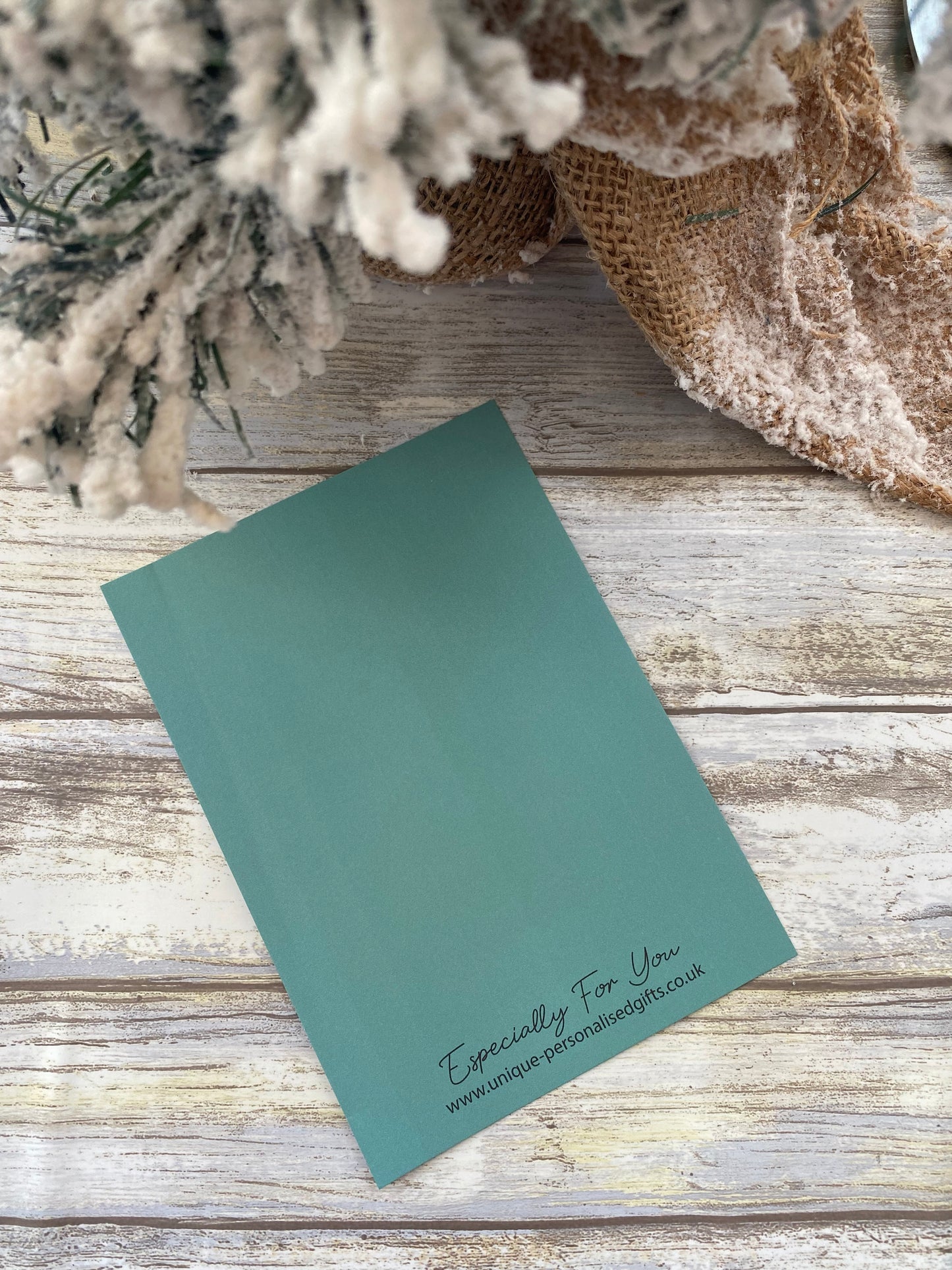 Green scratch card on a wooden surface with decorative elements
