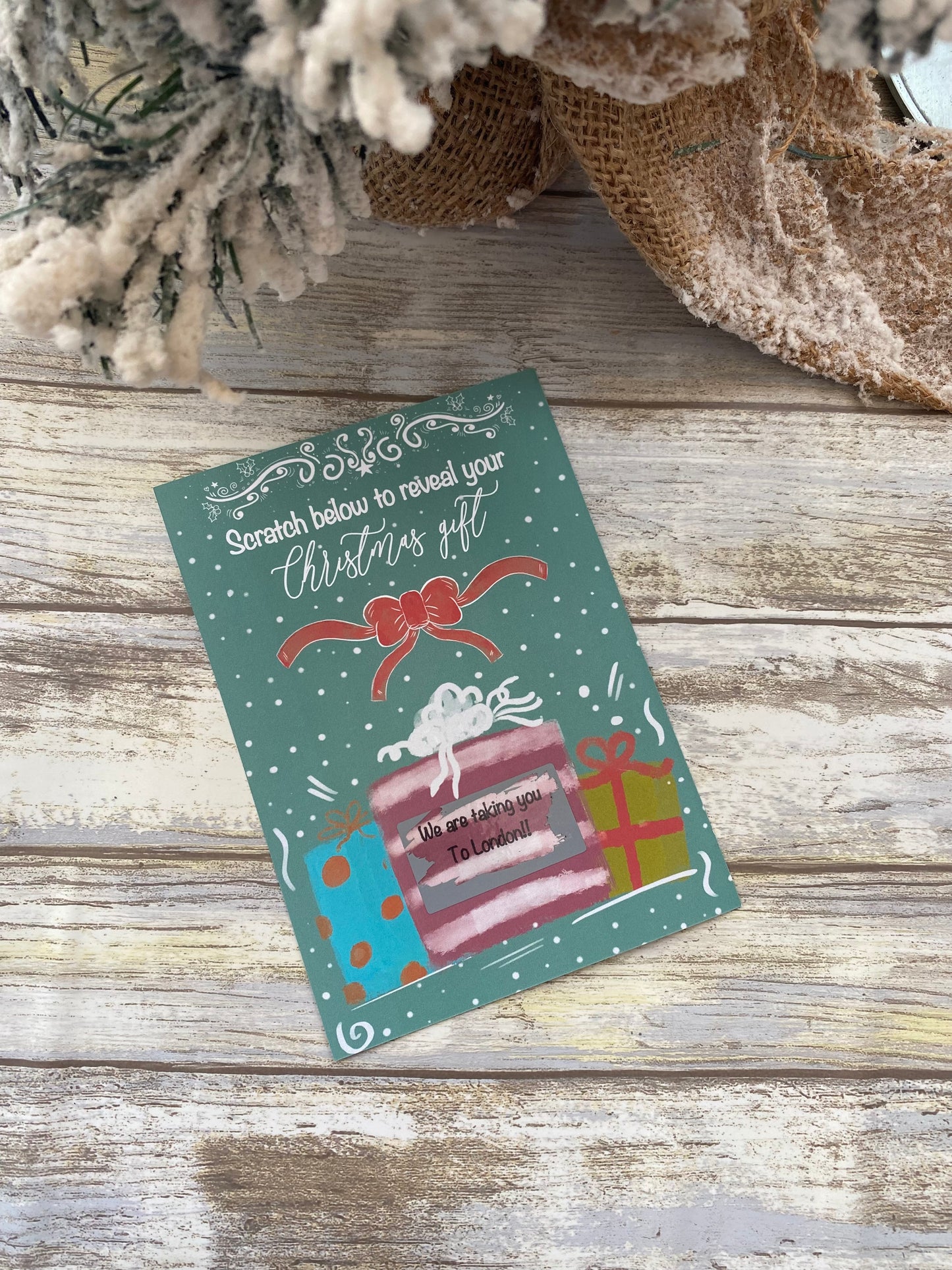 Christmas-themed scratch-off card on a wooden surface with decorative elements.
