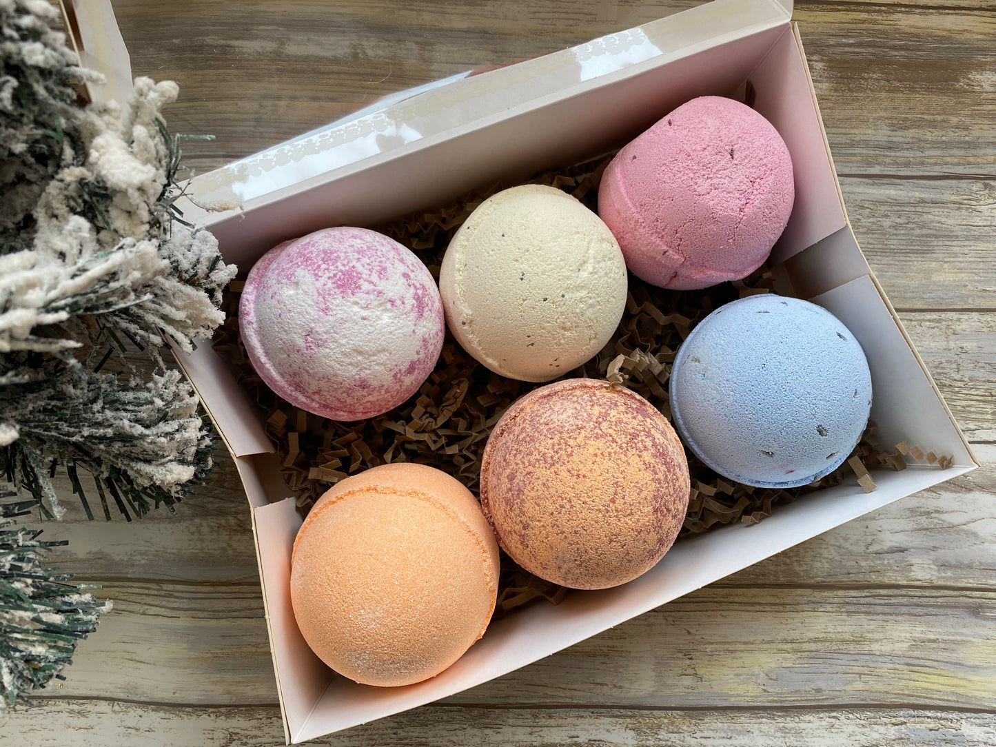 Box of colorful bath bombs on a wooden surface