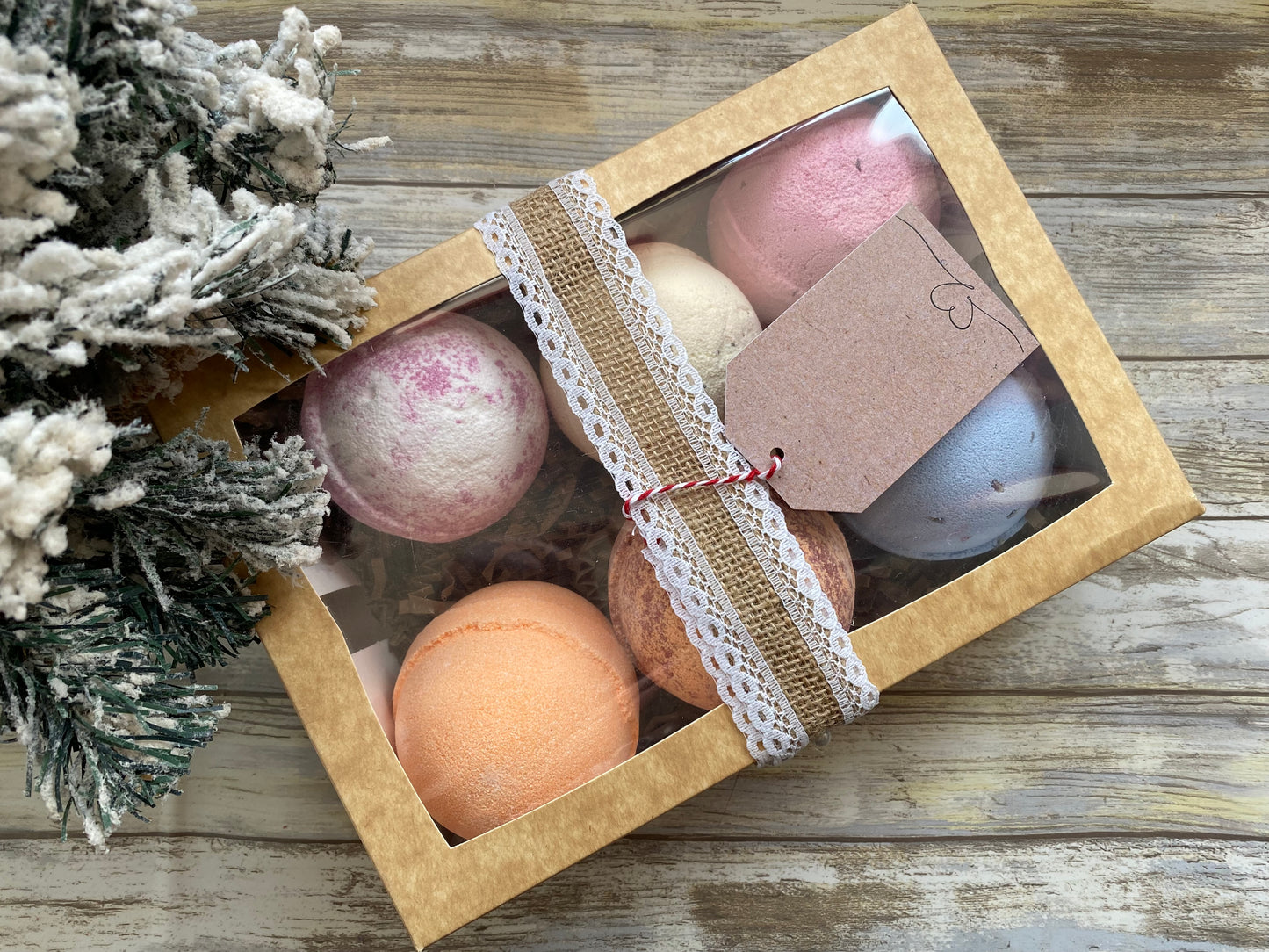 Box of bath bombs with decorative tag on a wooden surface