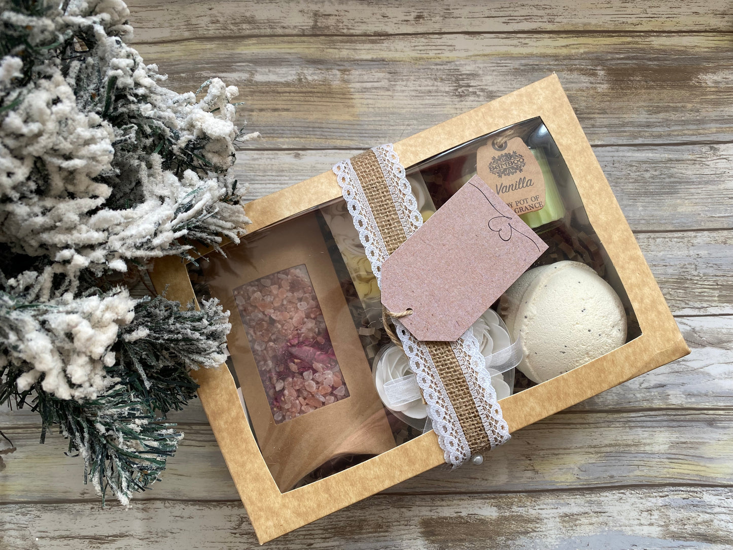 Gift set with bath bomb, soap, and bath salts on a wooden surface with decorative elements.