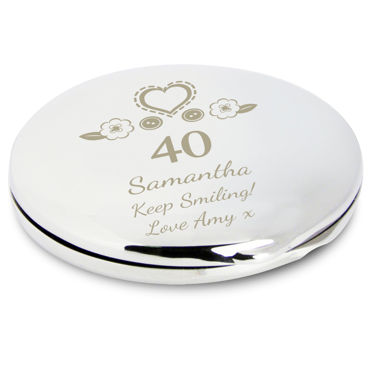 Silver compact mirror with engraved text and decorative elements on a white background