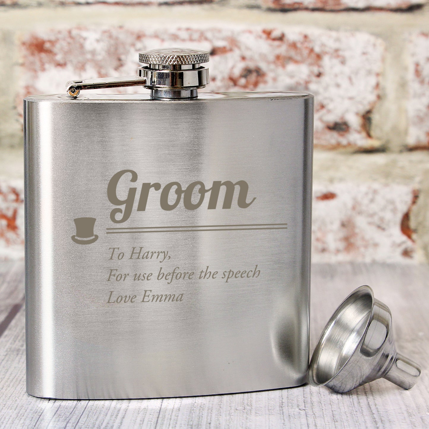 Stainless steel flask engraved with 'Groom' and personalised text, on a wooden surface.