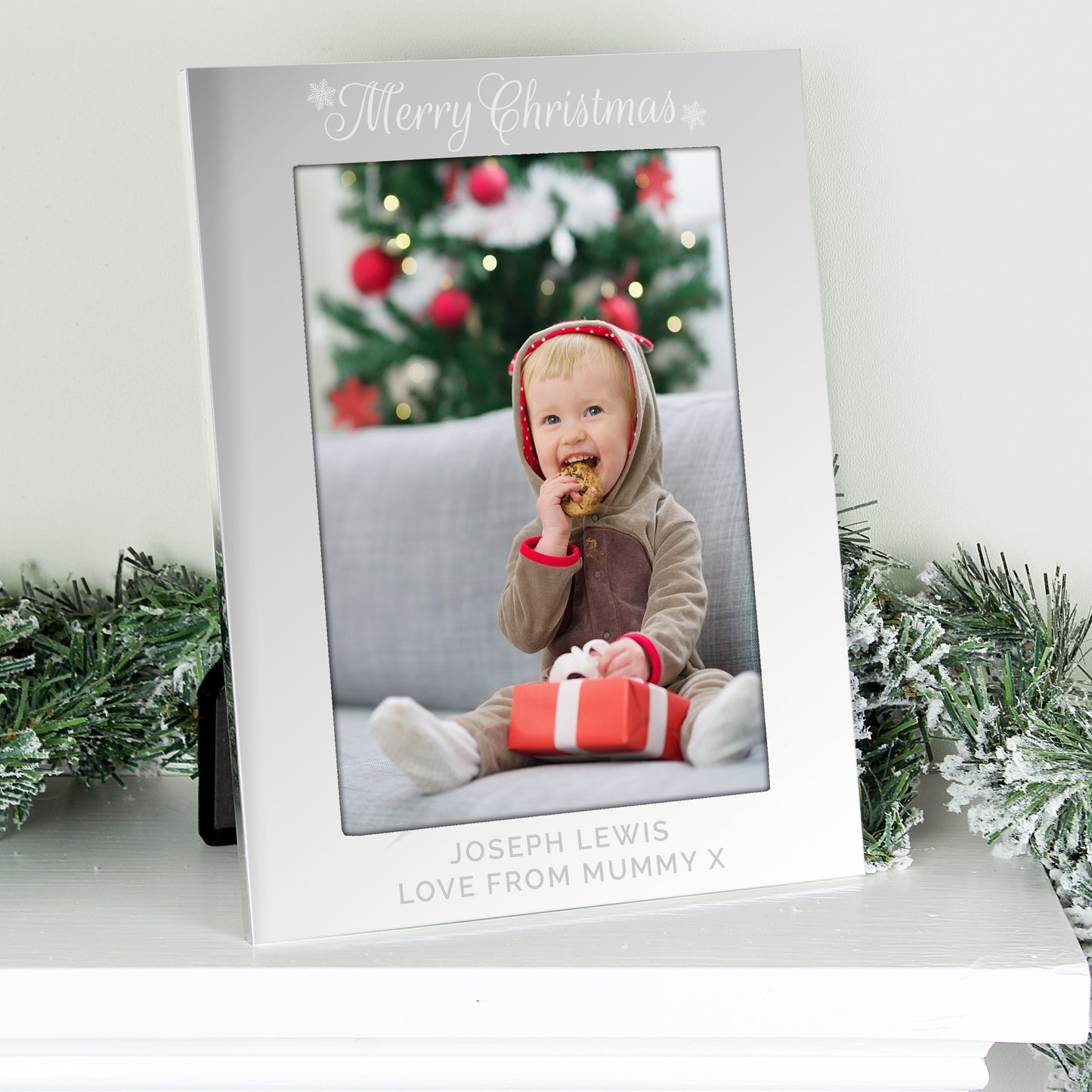 Personalised photo frame with a child's photo and Christmas tree in the background