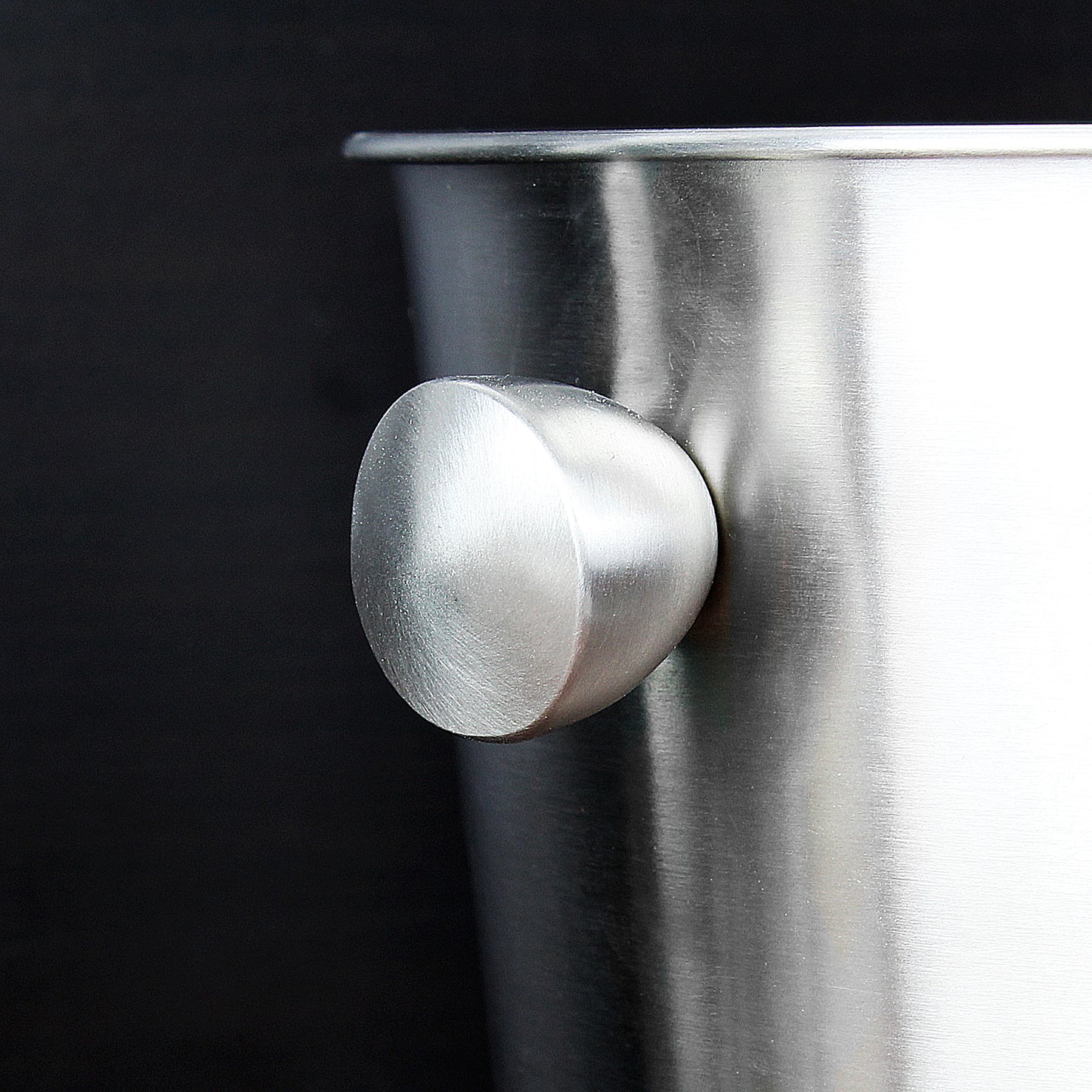 Close-up of a metallic knob on a dark background
