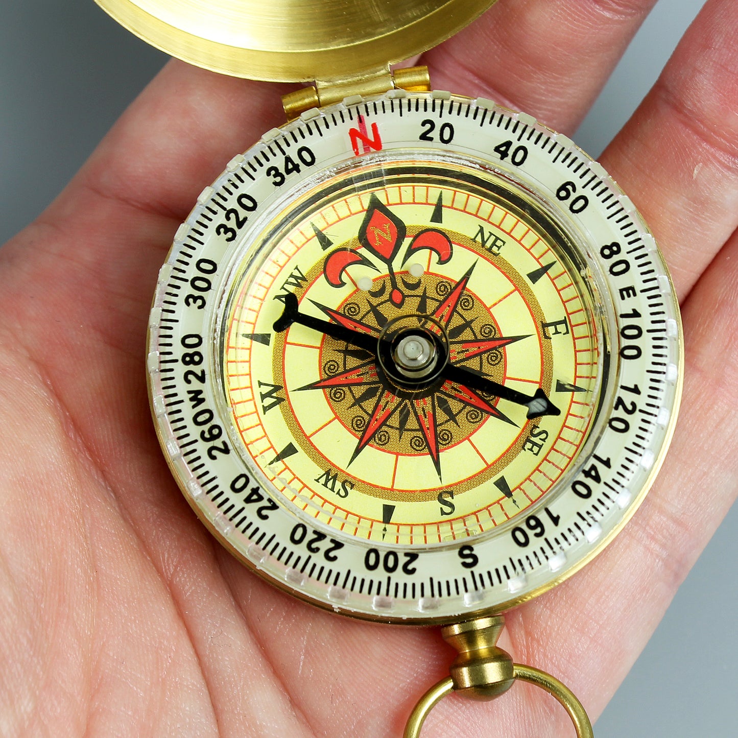 Compass held in a hand with a clear background