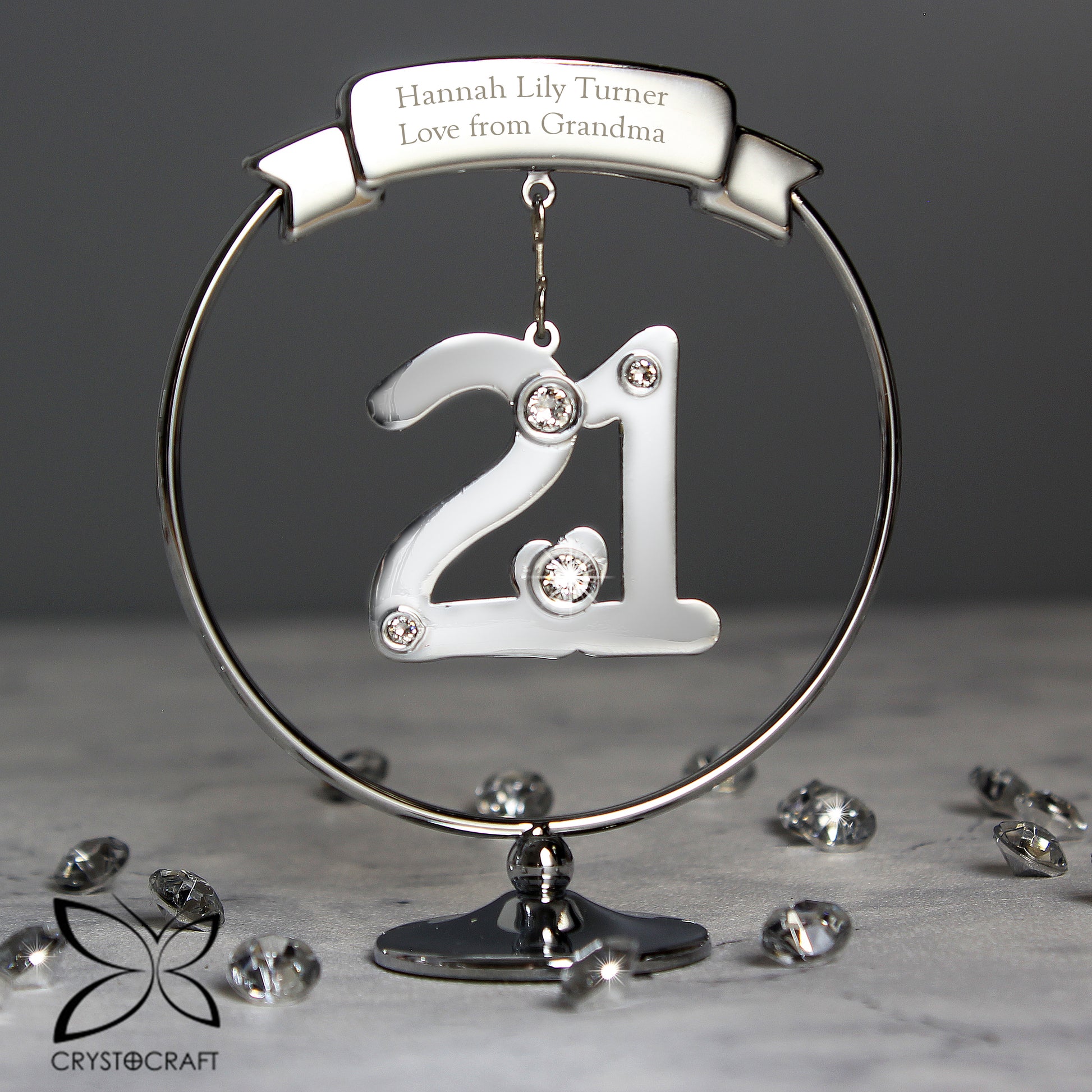 Decorative ornament with '21' and engraved text on a stand with scattered rhinestones.