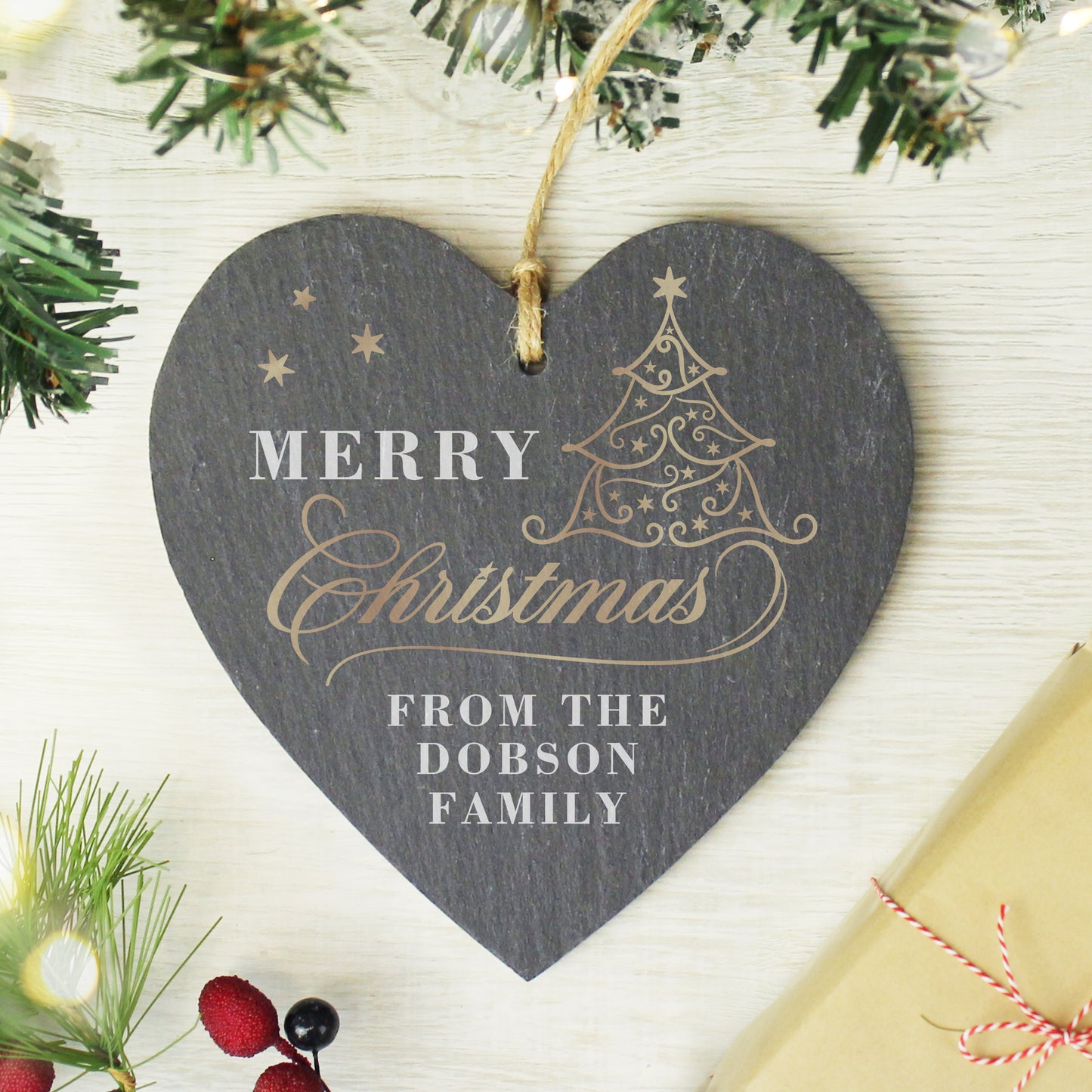 Heart-shaped Christmas ornament with 'Merry Christmas from the Dobson Family' text, surrounded by festive decorations.