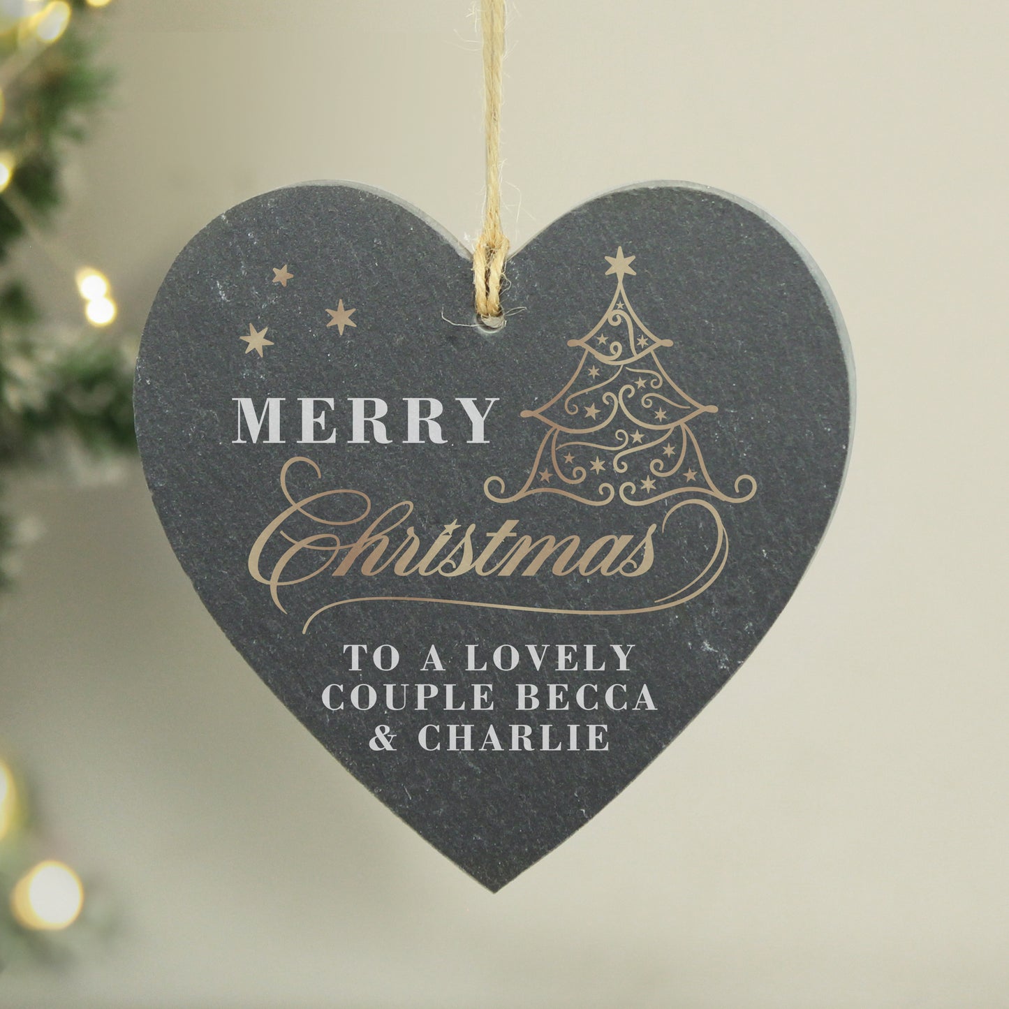 Heart-shaped Christmas ornament with 'Merry Christmas' and personalized message on a neutral background.