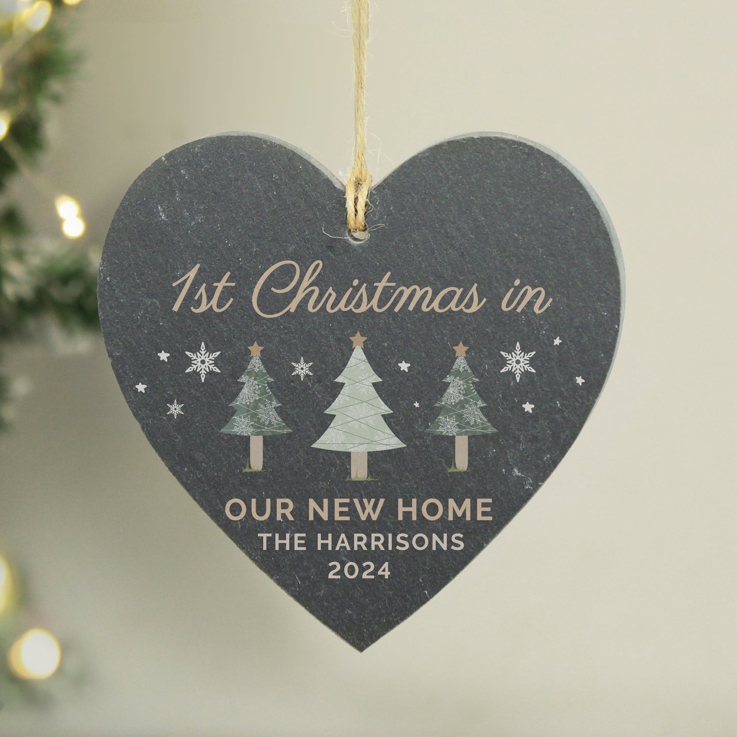 Heart-shaped decorative plaque for '1st Christmas in Our New Home' with personalized text, hanging against a neutral background.