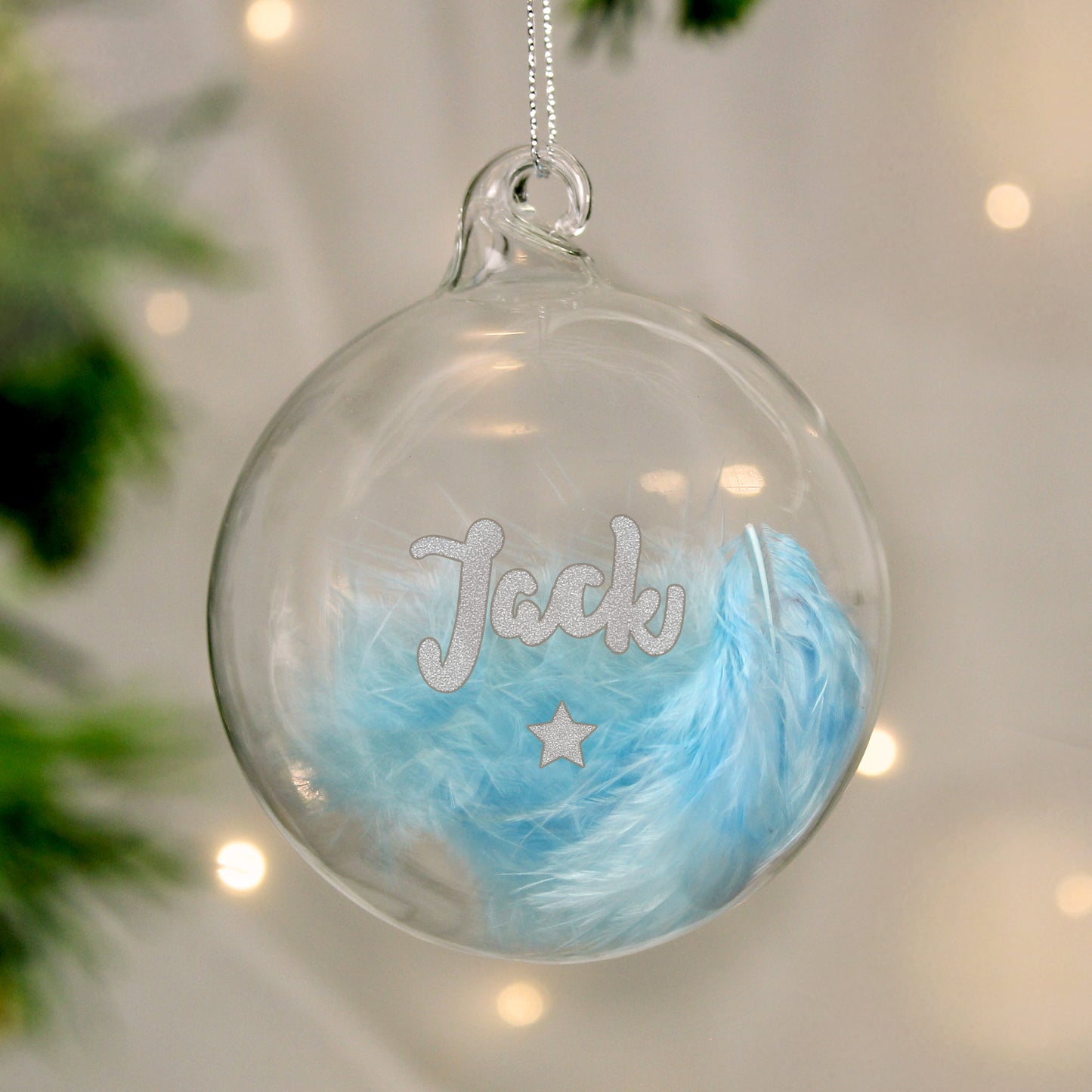 Personalised glass plastic bauble filled with soft blue feathers, showcasing the name “Jack” and a silver glitter star beneath. A charming custom decoration ideal for celebrating a baby boy's first Christmas or as a keepsake gift.