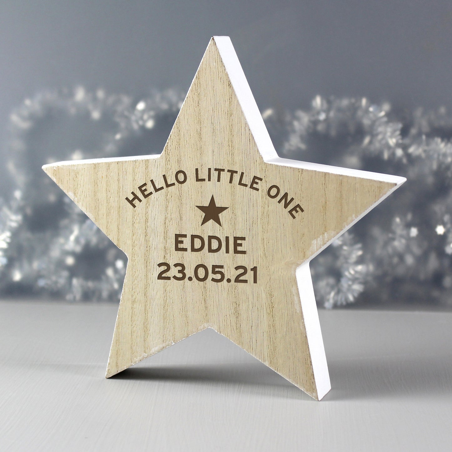Wooden star-shaped decoration with engraved text on a blurred background