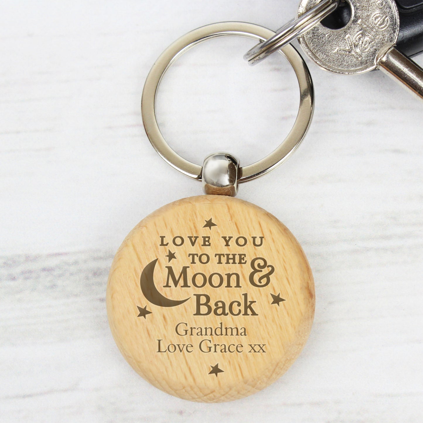 Wooden keychain with engraved message on a white background