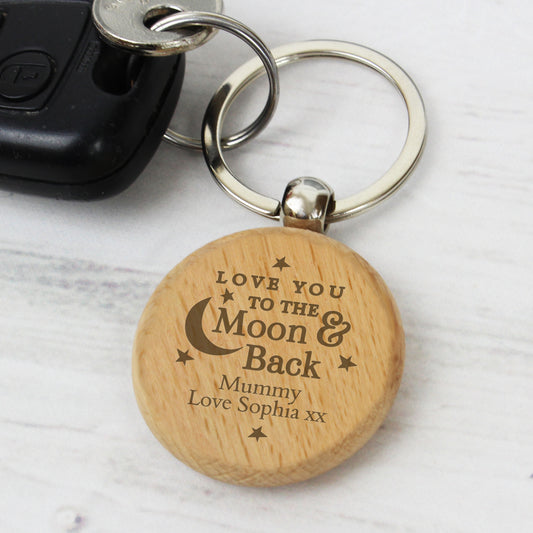 Wooden keychain with engraved message on a light background