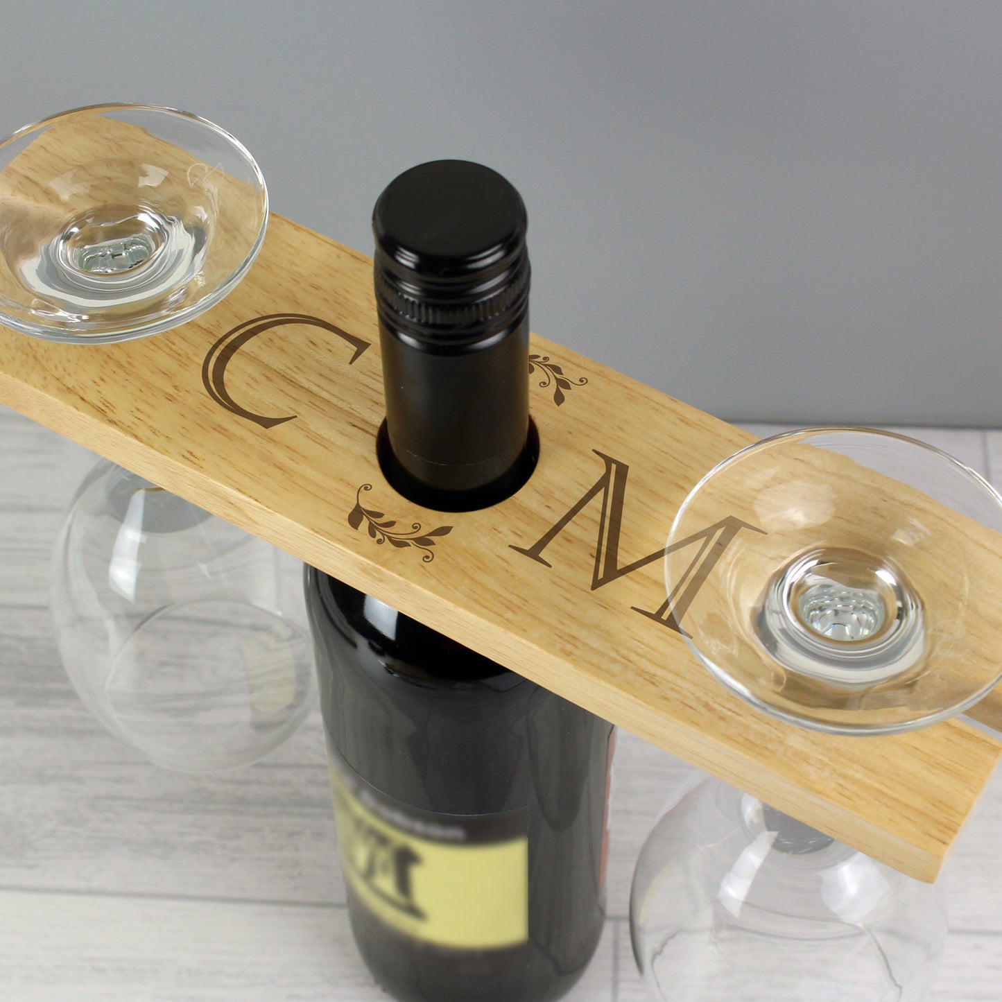 Personalised Wooden wine holder with two glasses and a bottle on a gray background
