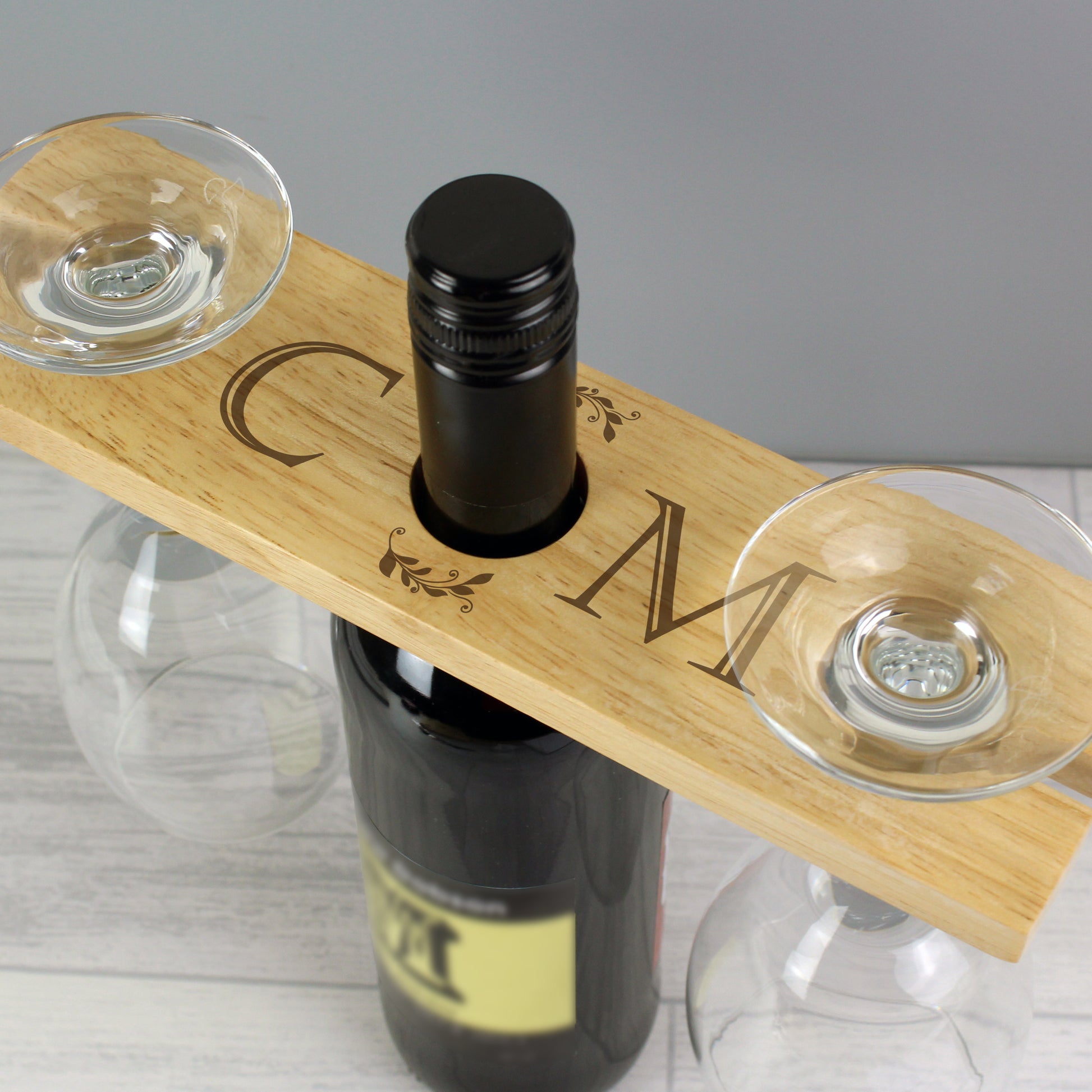 Personalised Wooden wine holder with two glasses and a bottle on a gray background