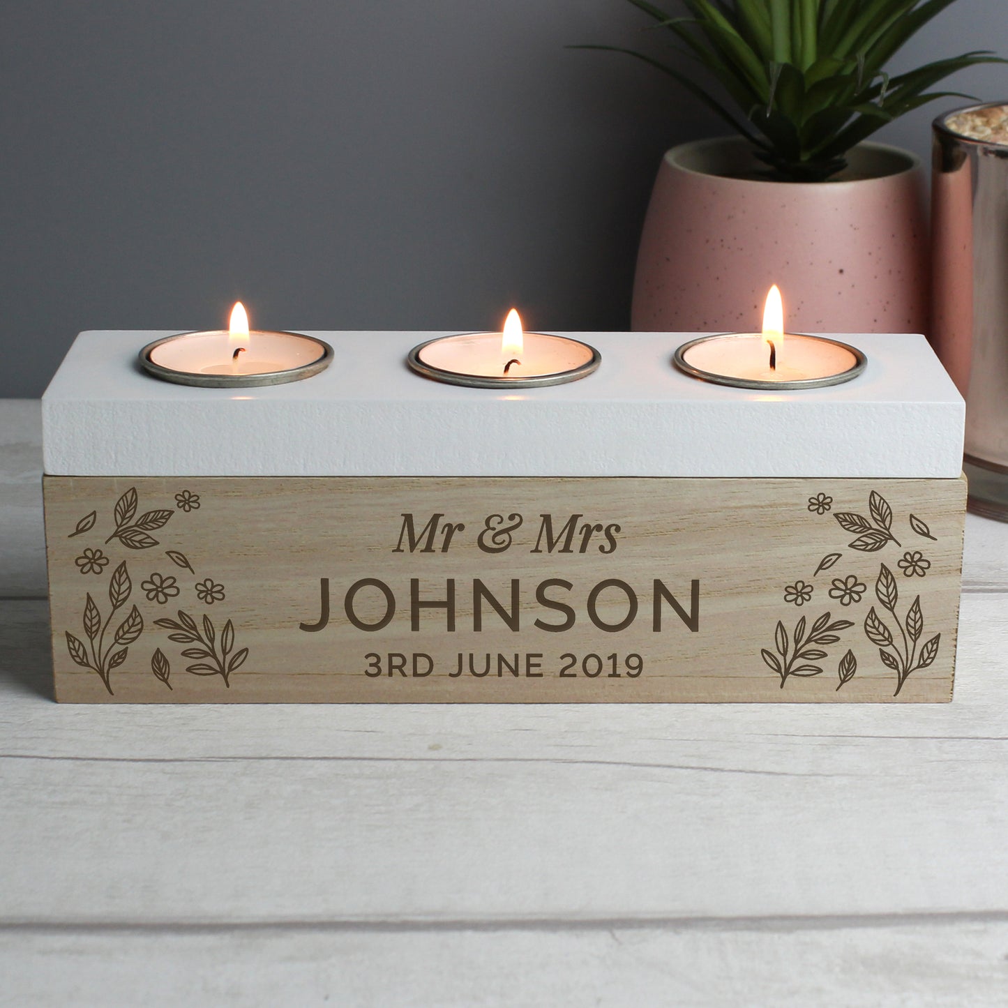 Three-wick candle holder with 'Mr & Mrs Johnson 3rd June 2019' engraving on a wooden base.