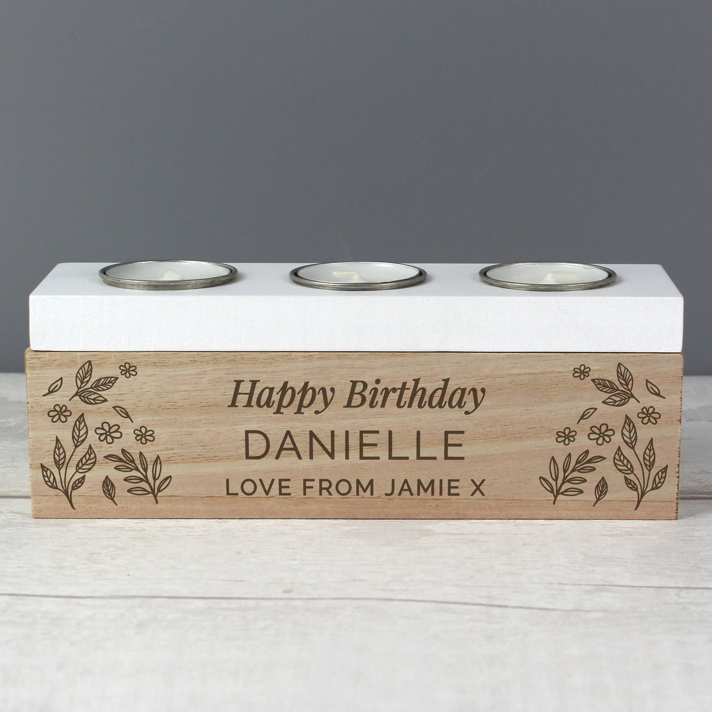 Personalised birthday candle holder with engraved text on a wooden base