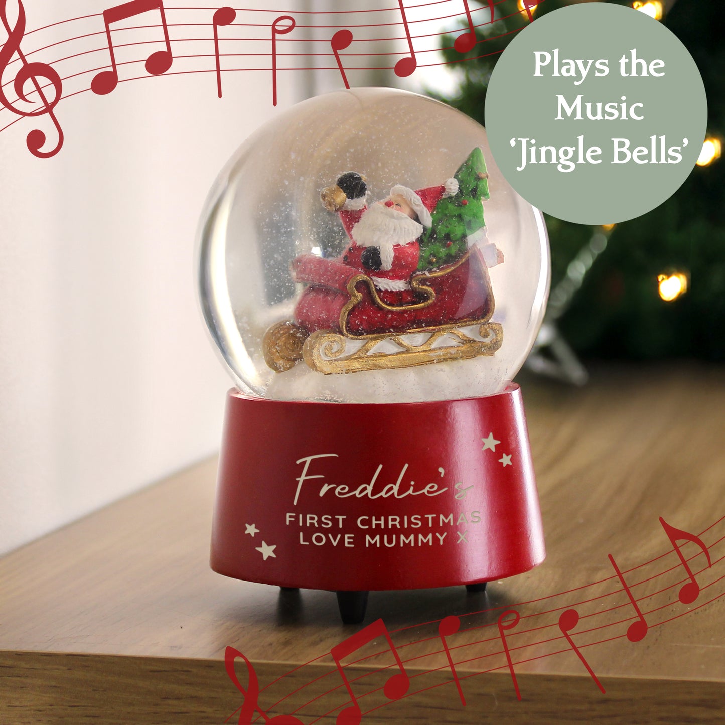 Christmas-themed snow globe with Santa Claus and tree, playing 'Jingle Bells', on a wooden surface.