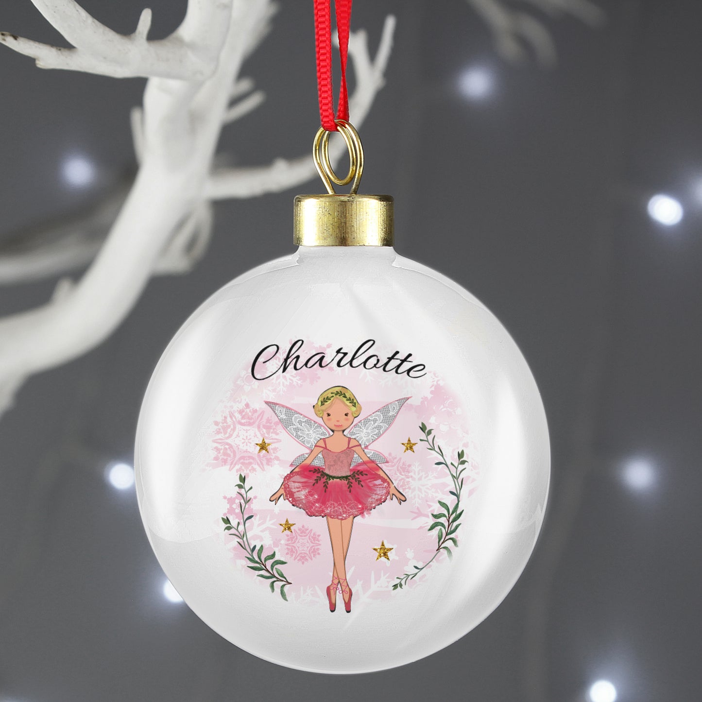 Decorative Christmas ball ornament with a fairy design and the name 'Charlotte' on a dark background.