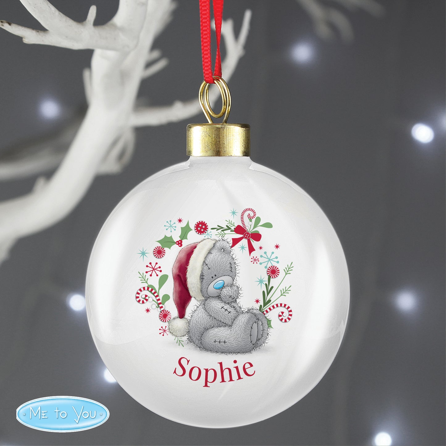 Christmas ornament with a teddy bear design and the name 'Sophie' on a dark background.