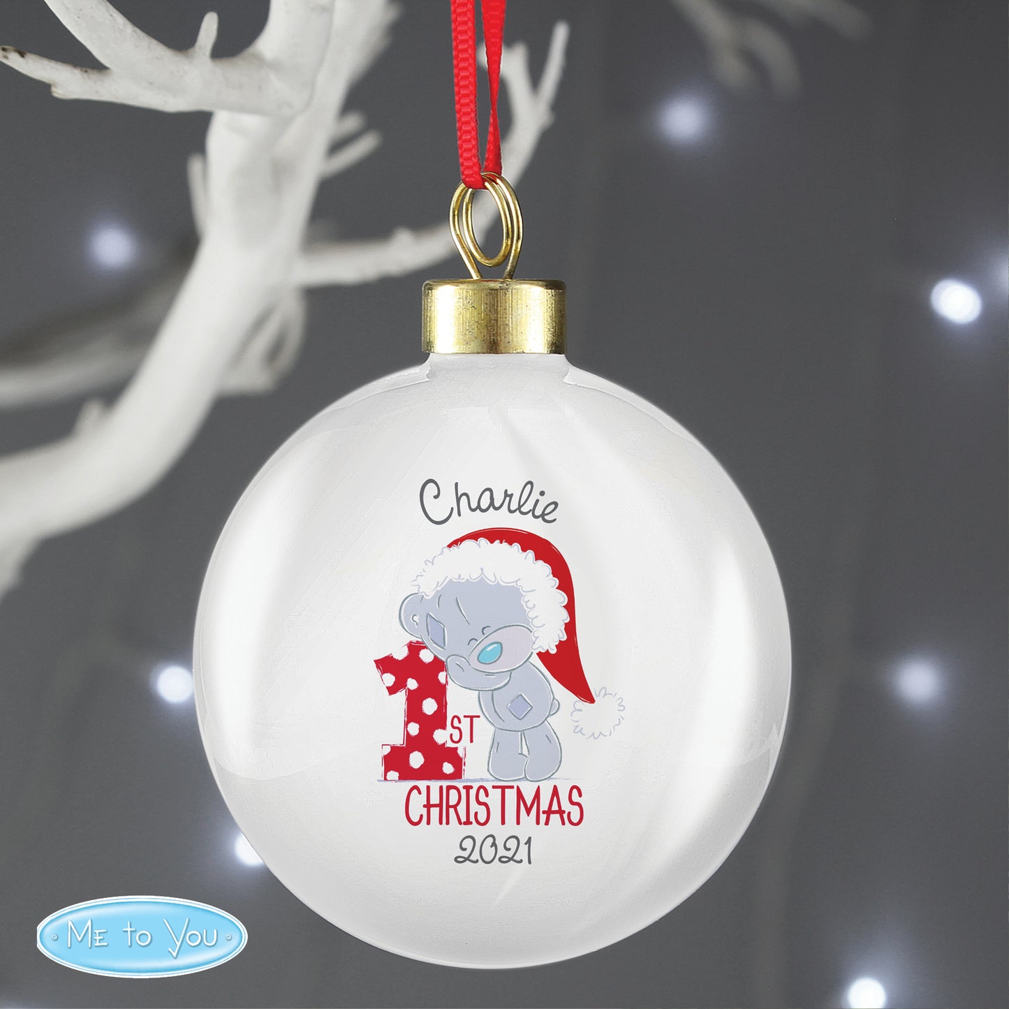 Christmas ornament with a cartoon bear and text 'Charlie 1st Christmas 2021' on a dark background.