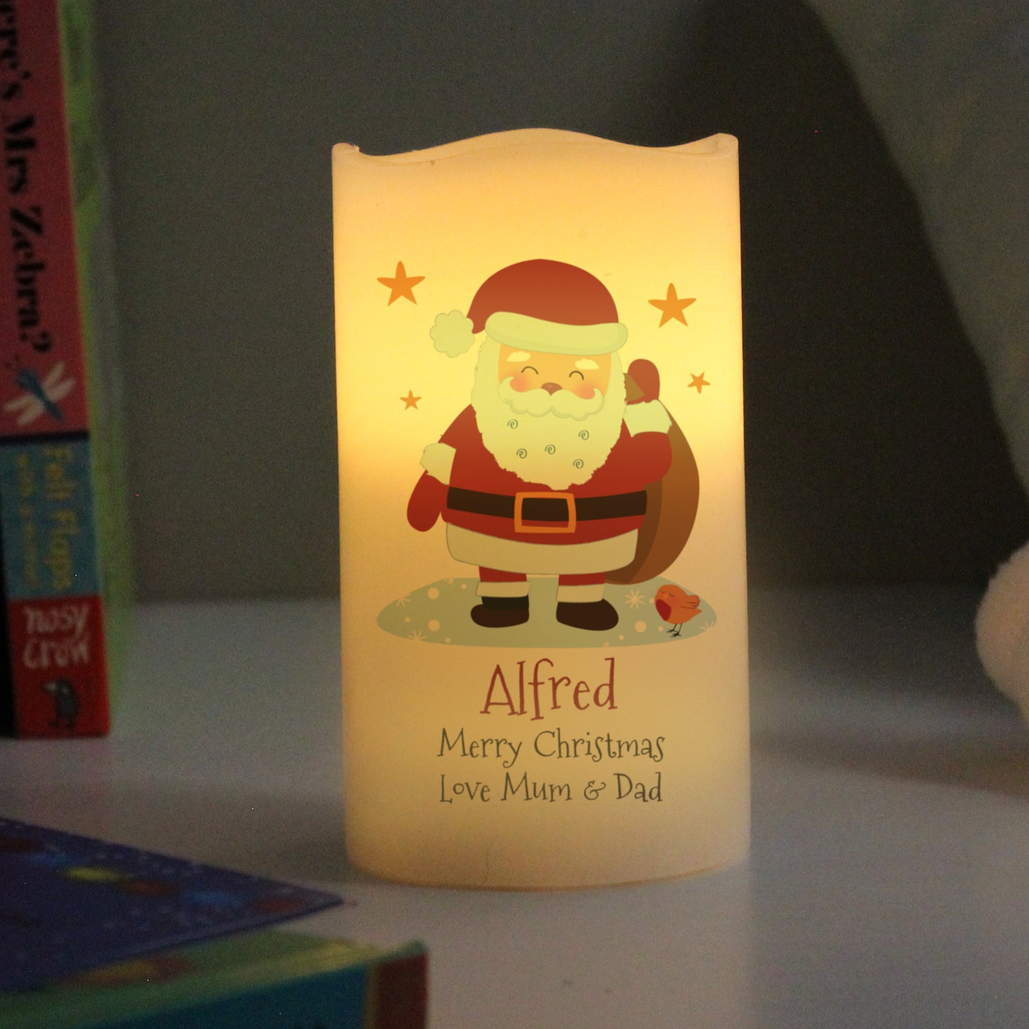 LED candle with Santa Claus design and personalized text on a dark background