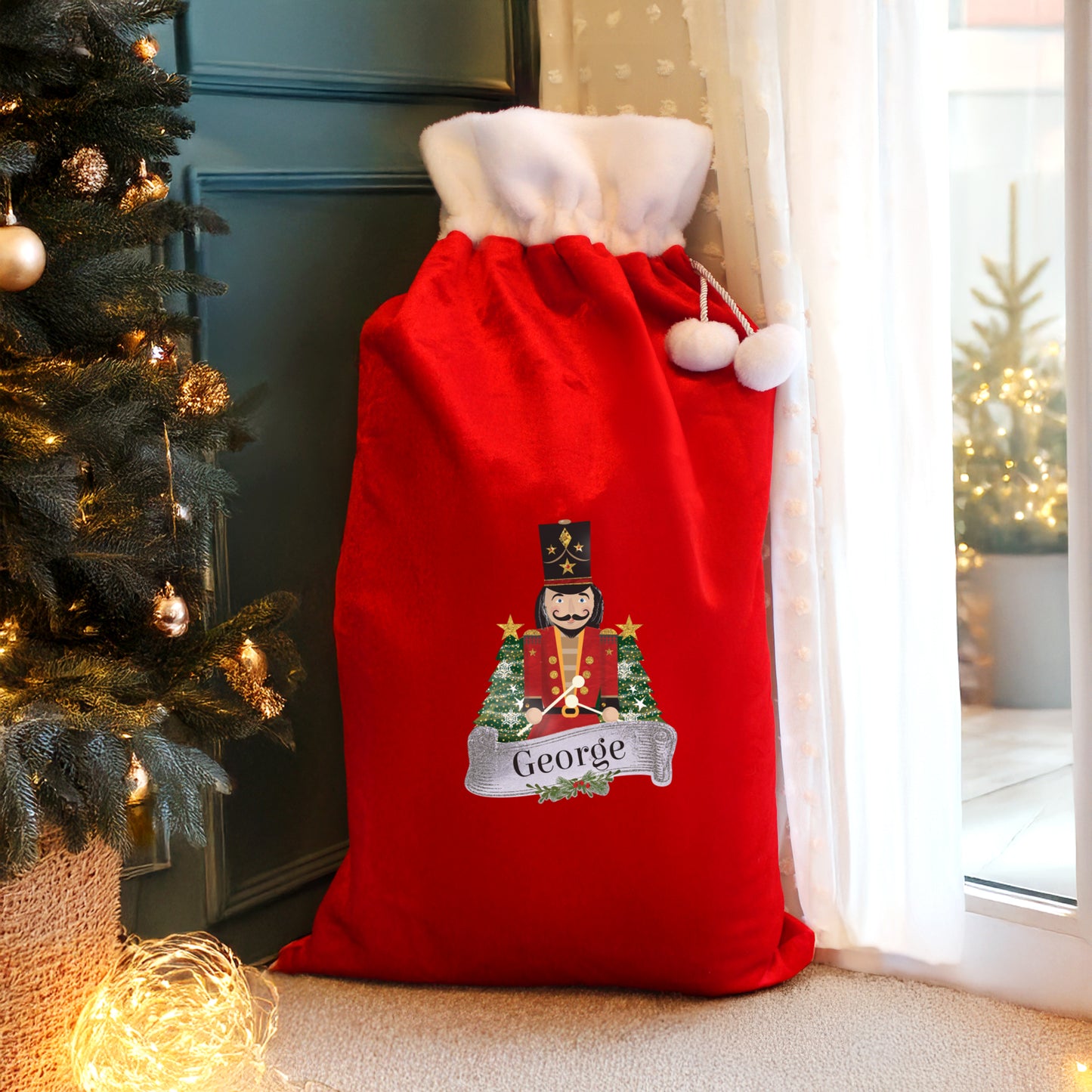 Personalised Red Christmas sack with the name 'George' next to a decorated Christmas tree.