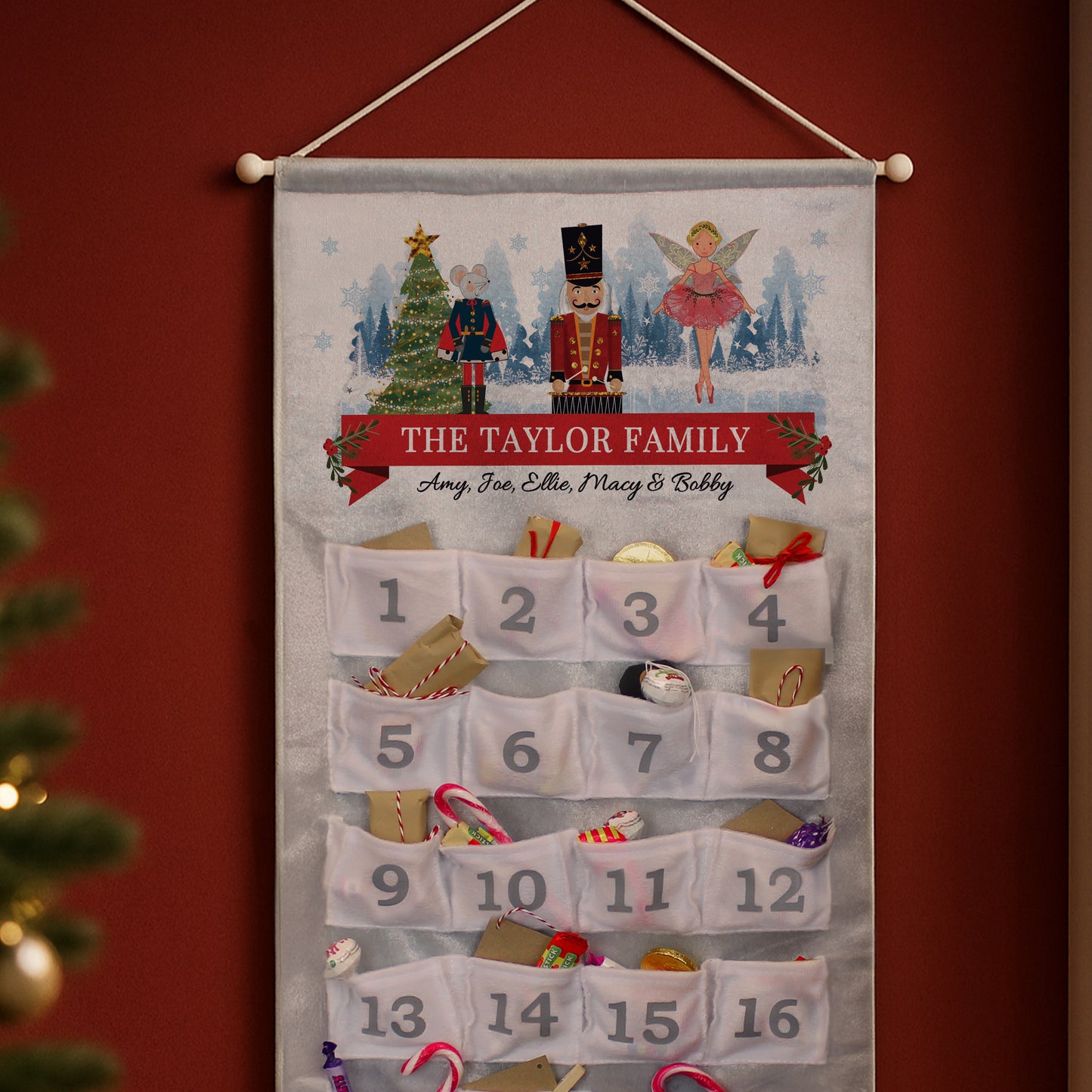 Personalised advent calendar for The Taylor Family against a red wall with Christmas decorations.