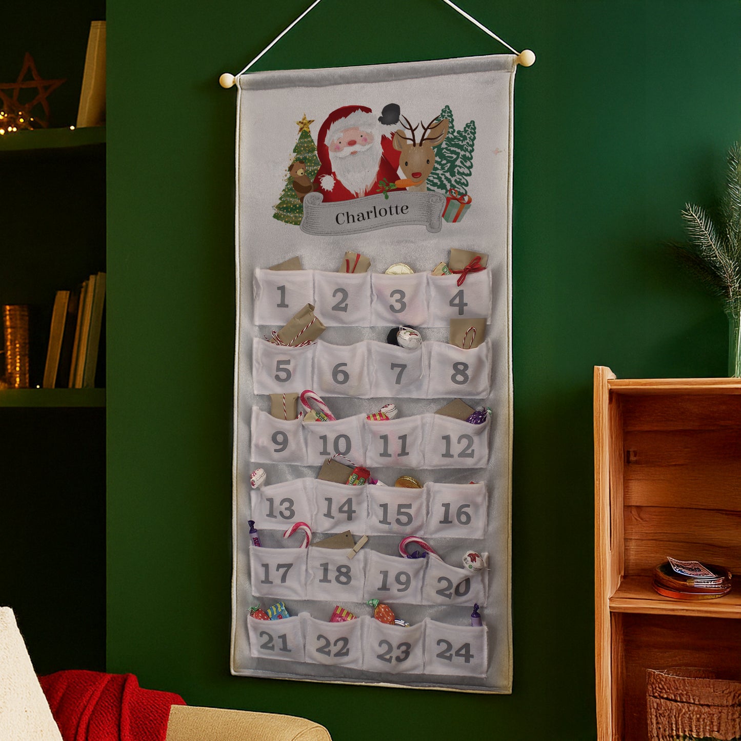 Personalised Christmas-themed advent calendar with Santa Claus and reindeer design on a green wall.