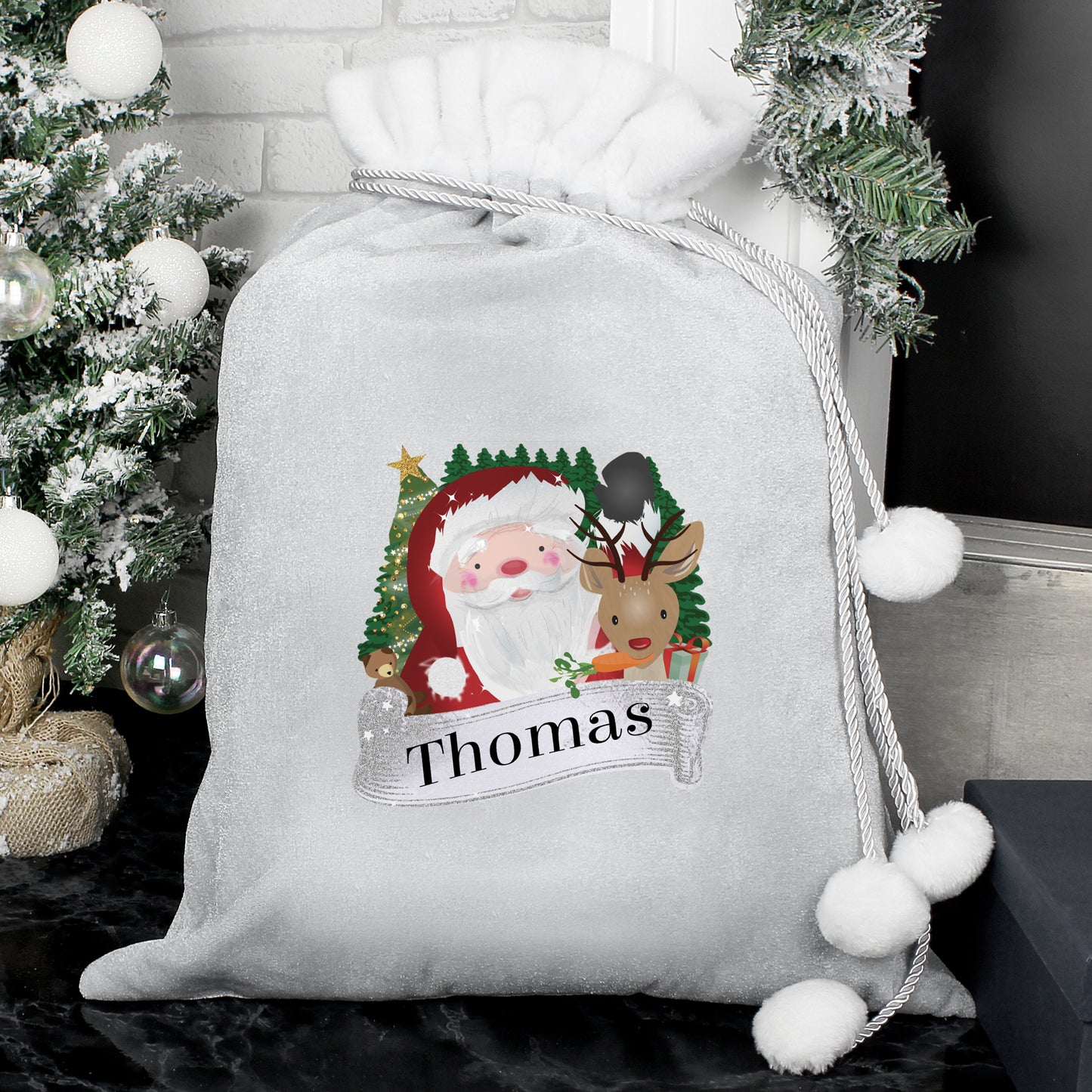Personalised Christmas sack with Santa and reindeer design, decorated with white pom-poms, against a festive background.
