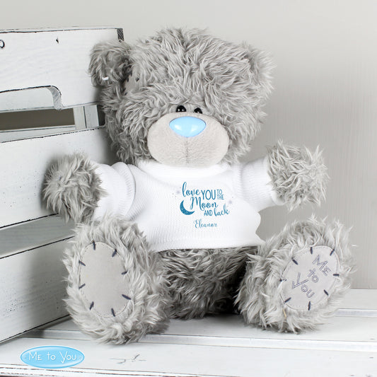 Plush teddy bear with a personalised message on a white wooden surface