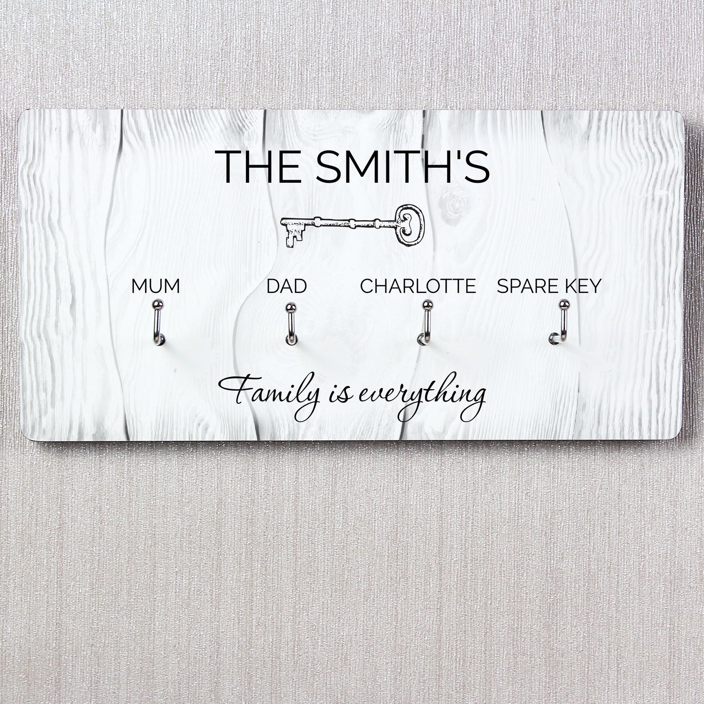 Personalised Key holder with keys for 'Mum', 'Dad', 'Charlotte', and 'Spare Key' on a white wooden background.