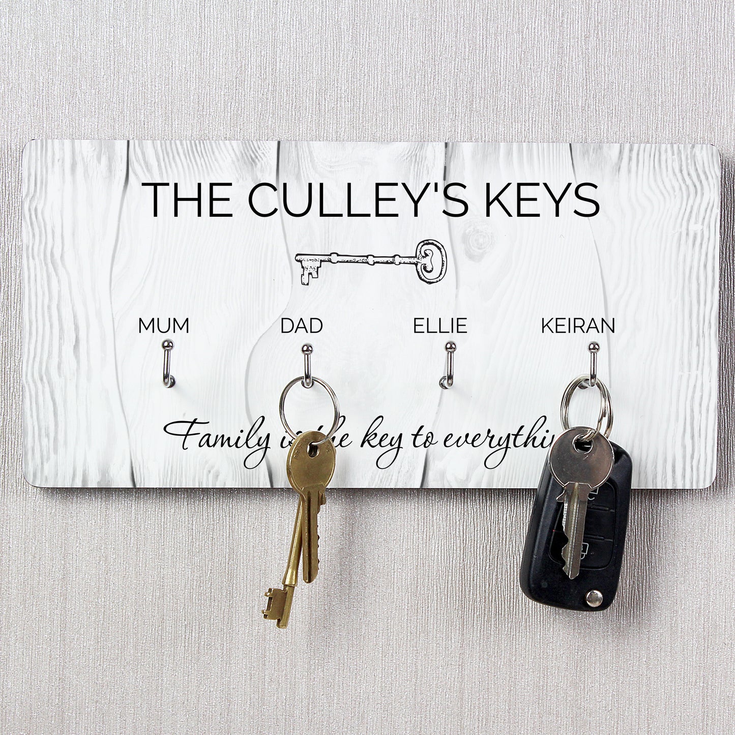 Key holder with keys attached, personalised with family names on a light gray background