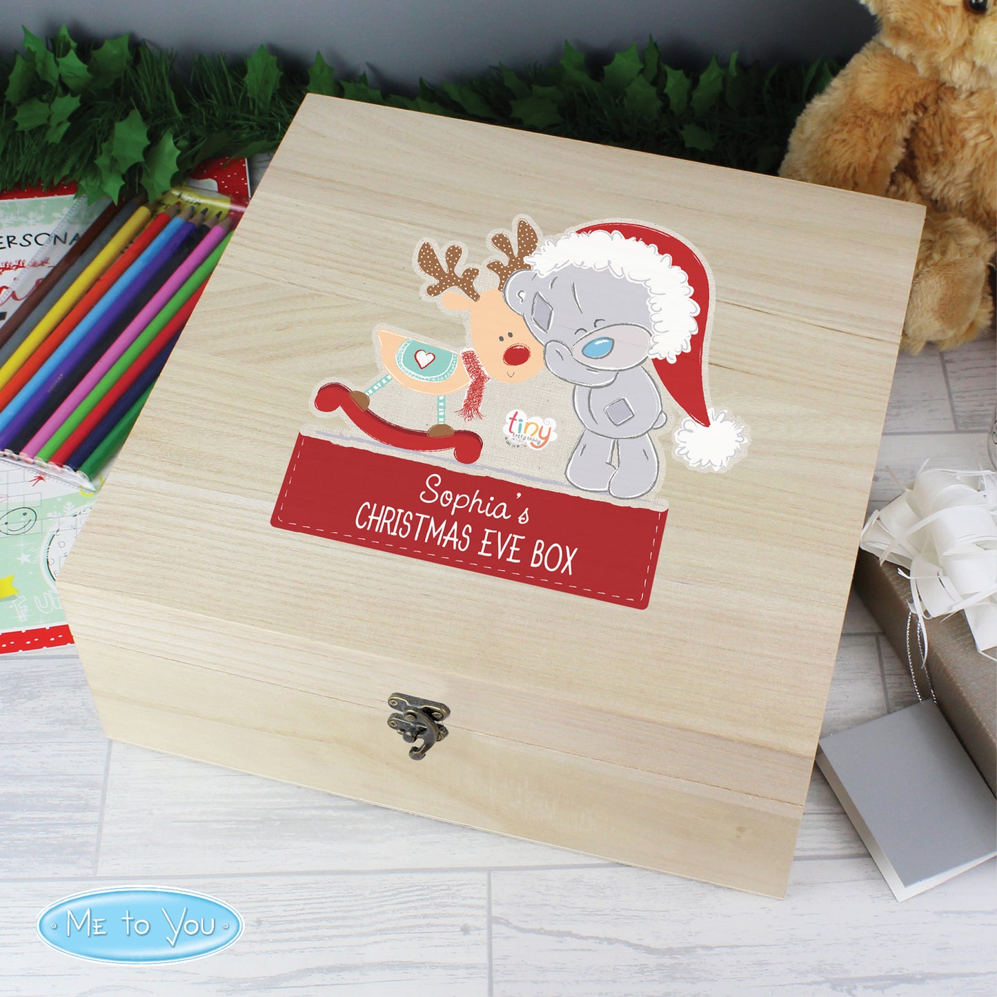 Wooden Christmas Eve box with cartoon characters and 'Sophia's Christmas Eve Box' label, surrounded by festive items.