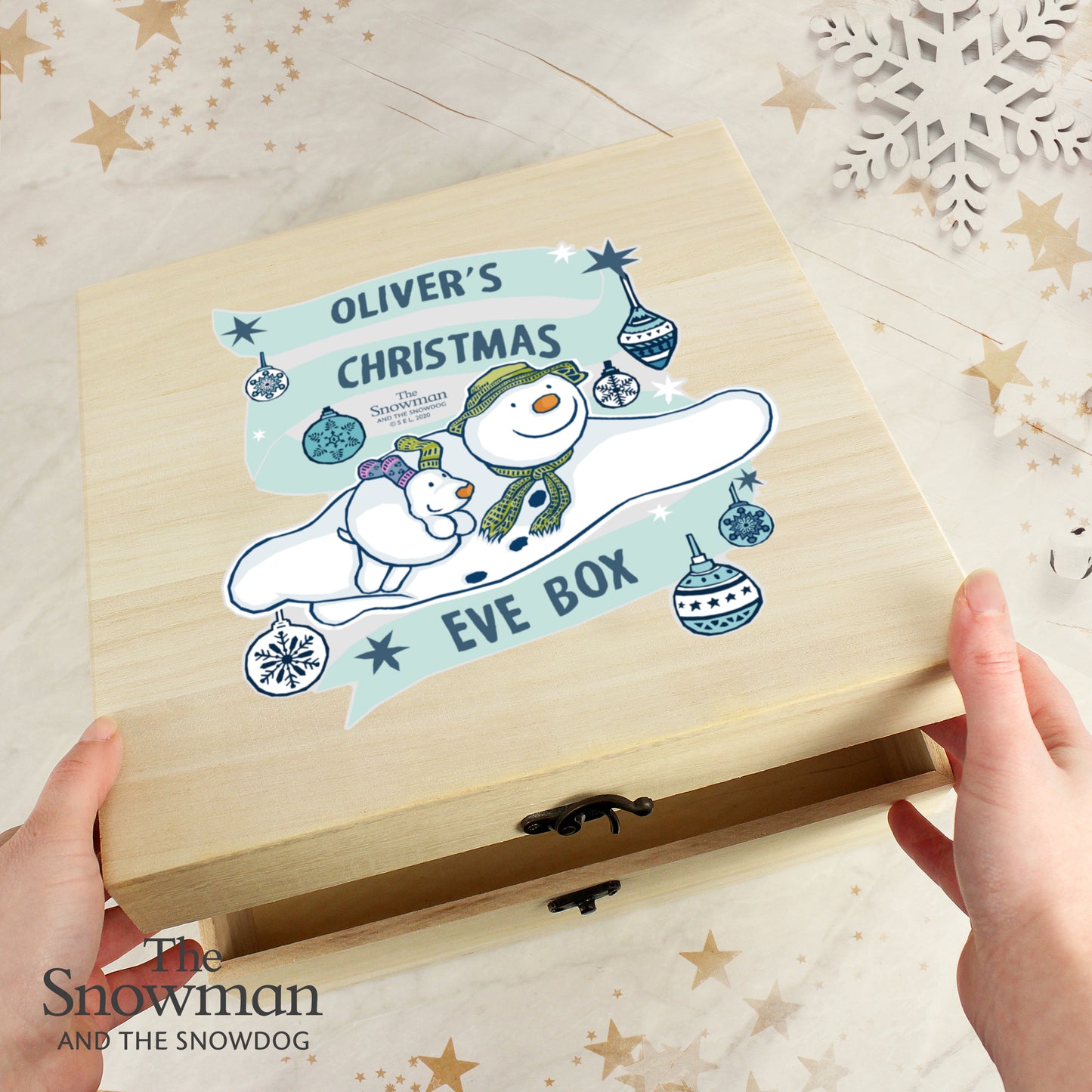 Wooden box with a snowman design and text on a decorative surface.