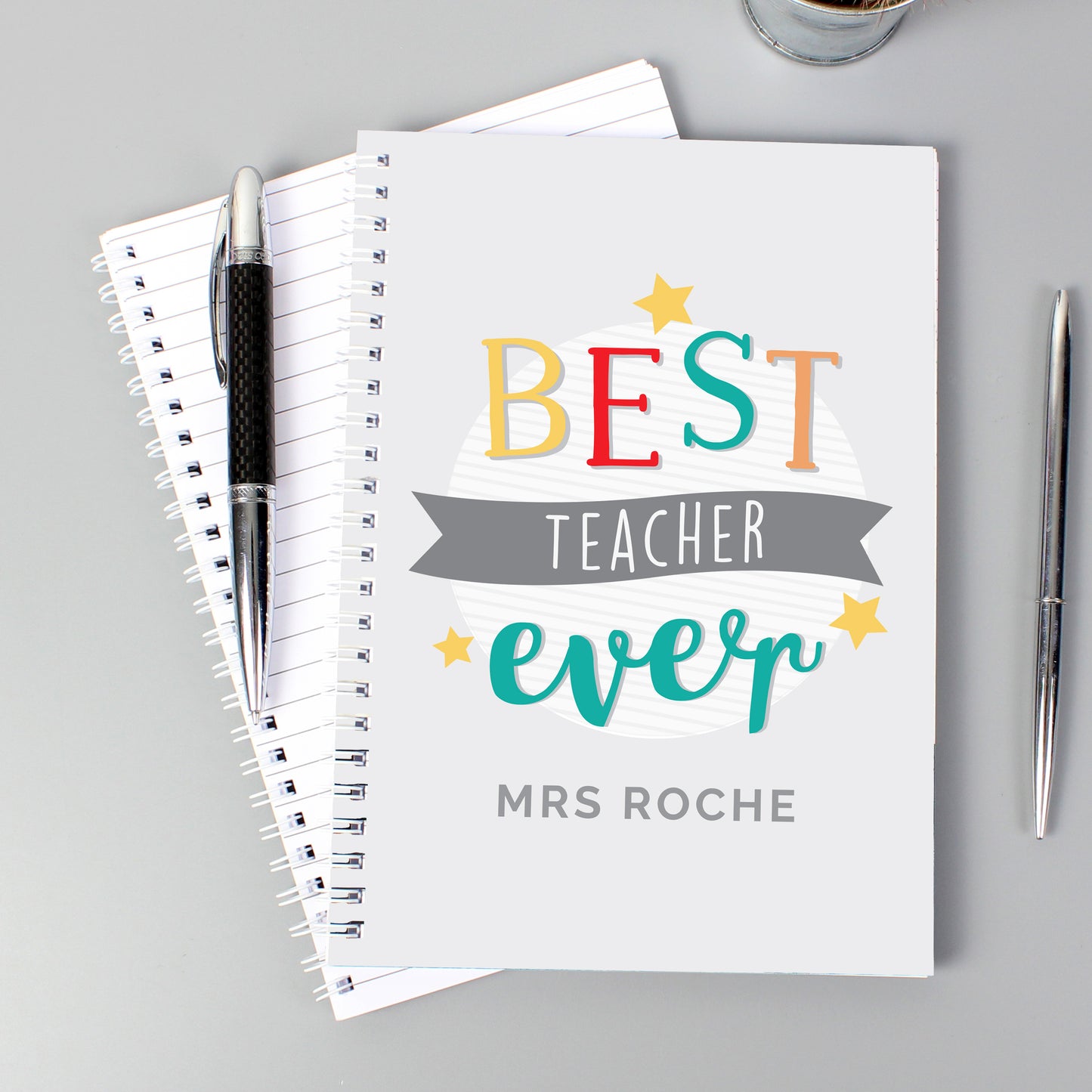 Notebook with 'Best Teacher Ever' text on a gray background