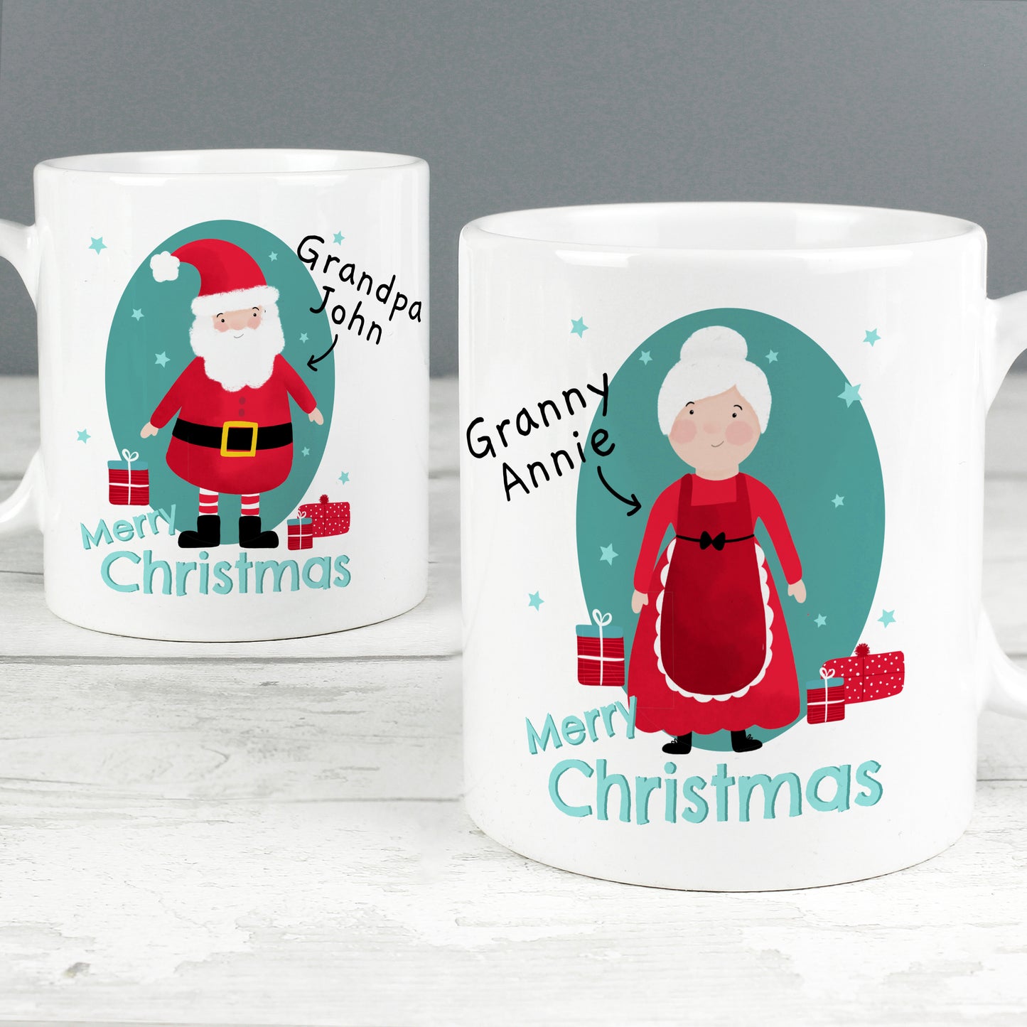 Two Christmas-themed mugs with Santa and Mrs. Claus illustrations on a gray background.