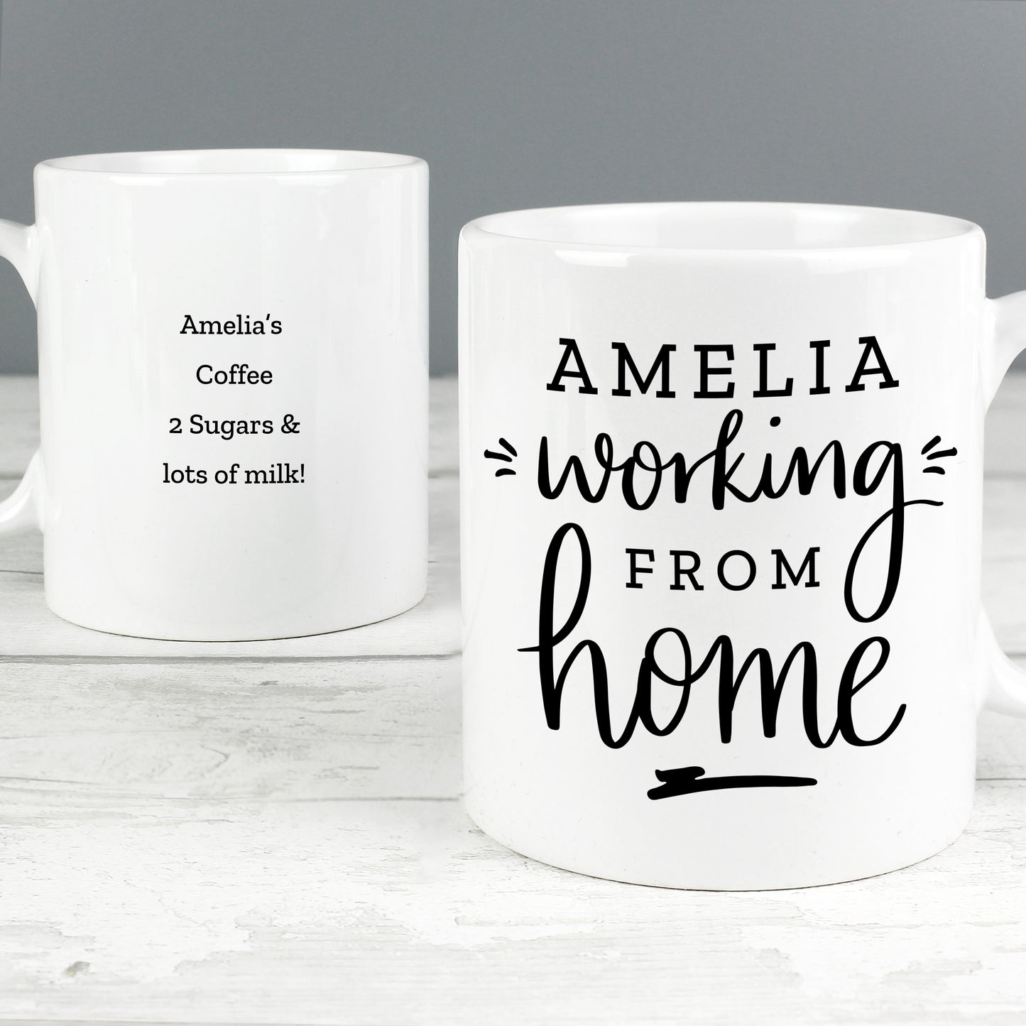 Two white mugs with personalized text on a gray background