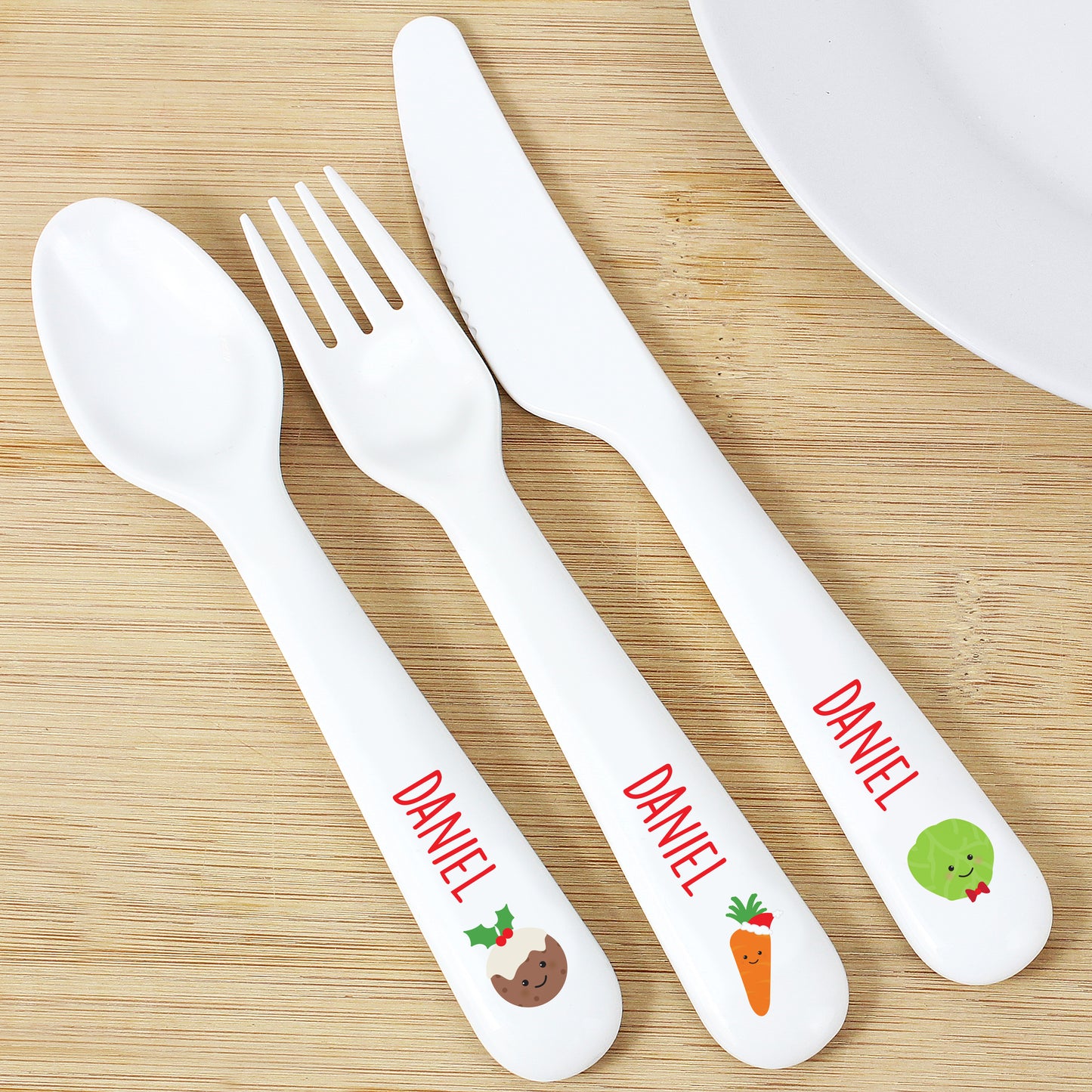 Personalised White cutlery set with 'DANIEL' branding on a wooden surface