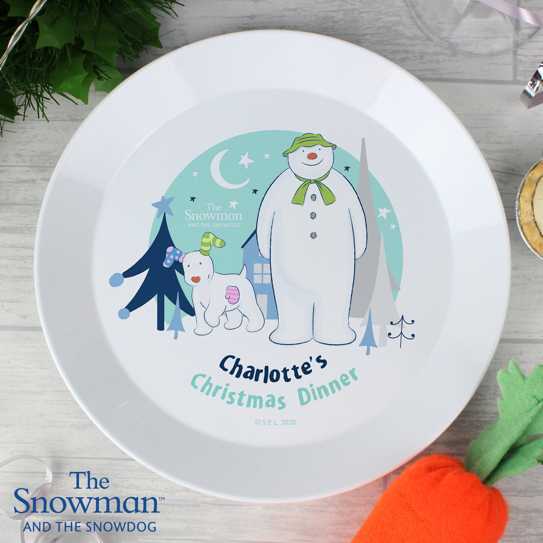 White baby Christmas plate with The Snowman and the Snowdog illustration, stars, moon, and custom name, licensed design